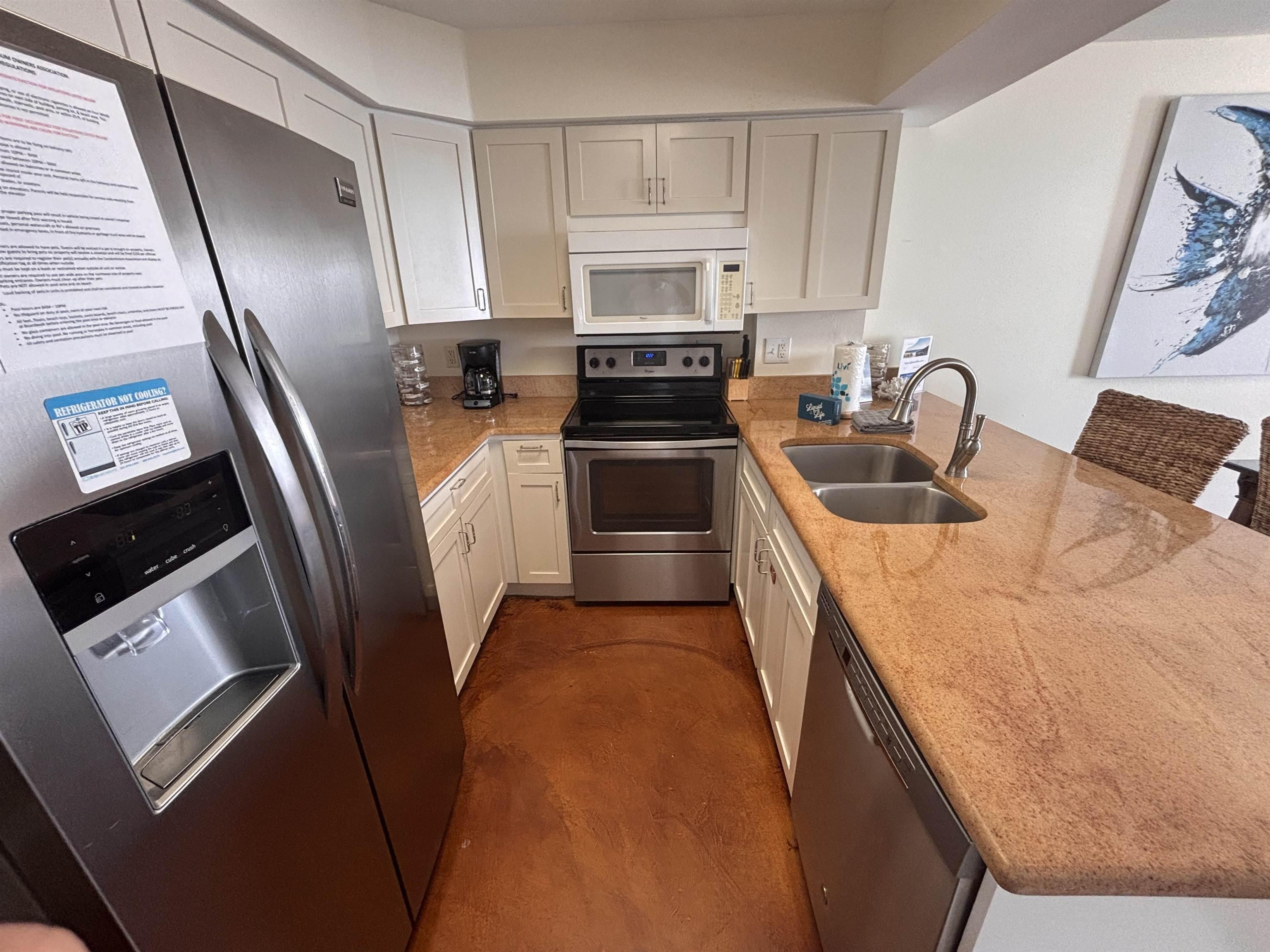 Image 3: Kitchen with stainless steel appliances, light stone counters, a peninsula, and white cabinets