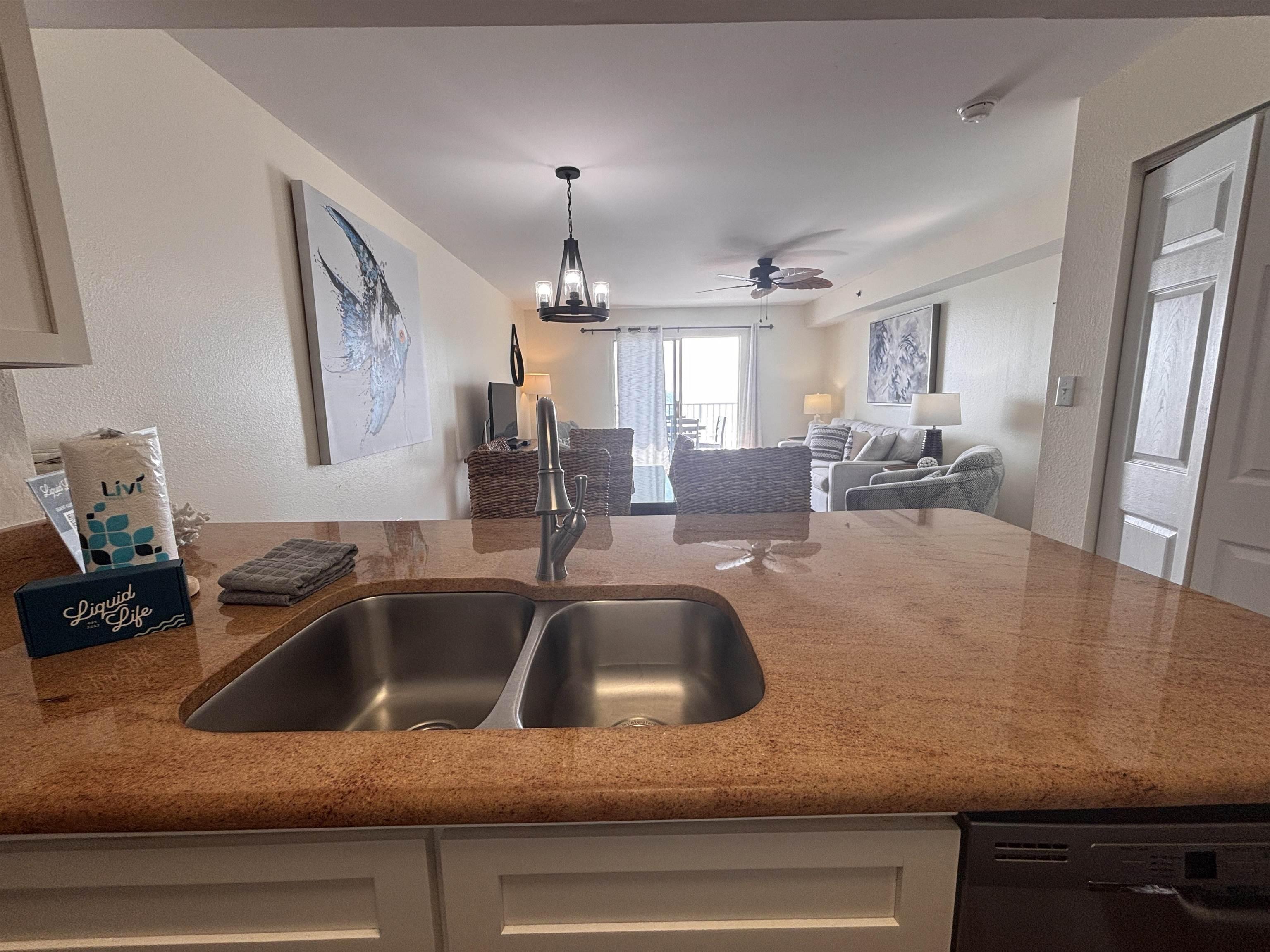 Image 4: Kitchen featuring dark stone countertops, a textured wall, open floor plan, black dishwasher, and a ceiling fan
