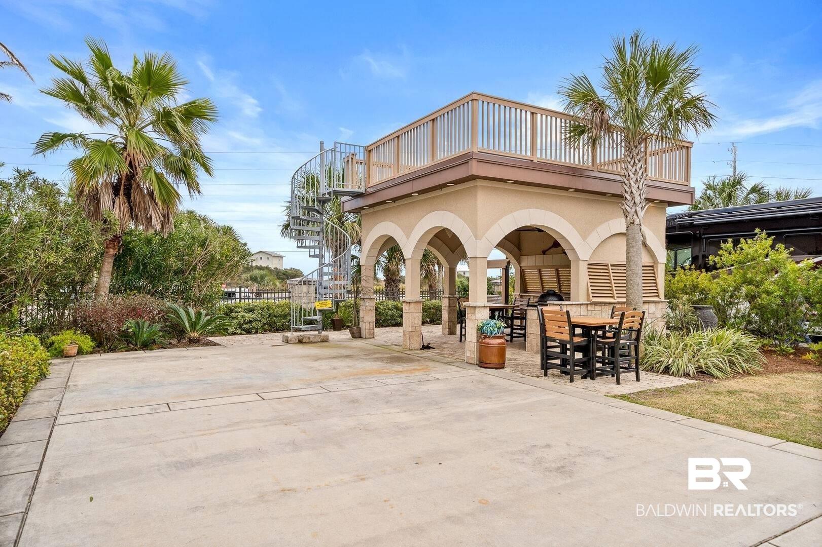Image 2: Rear view of property featuring stairs, a patio area, and stucco siding