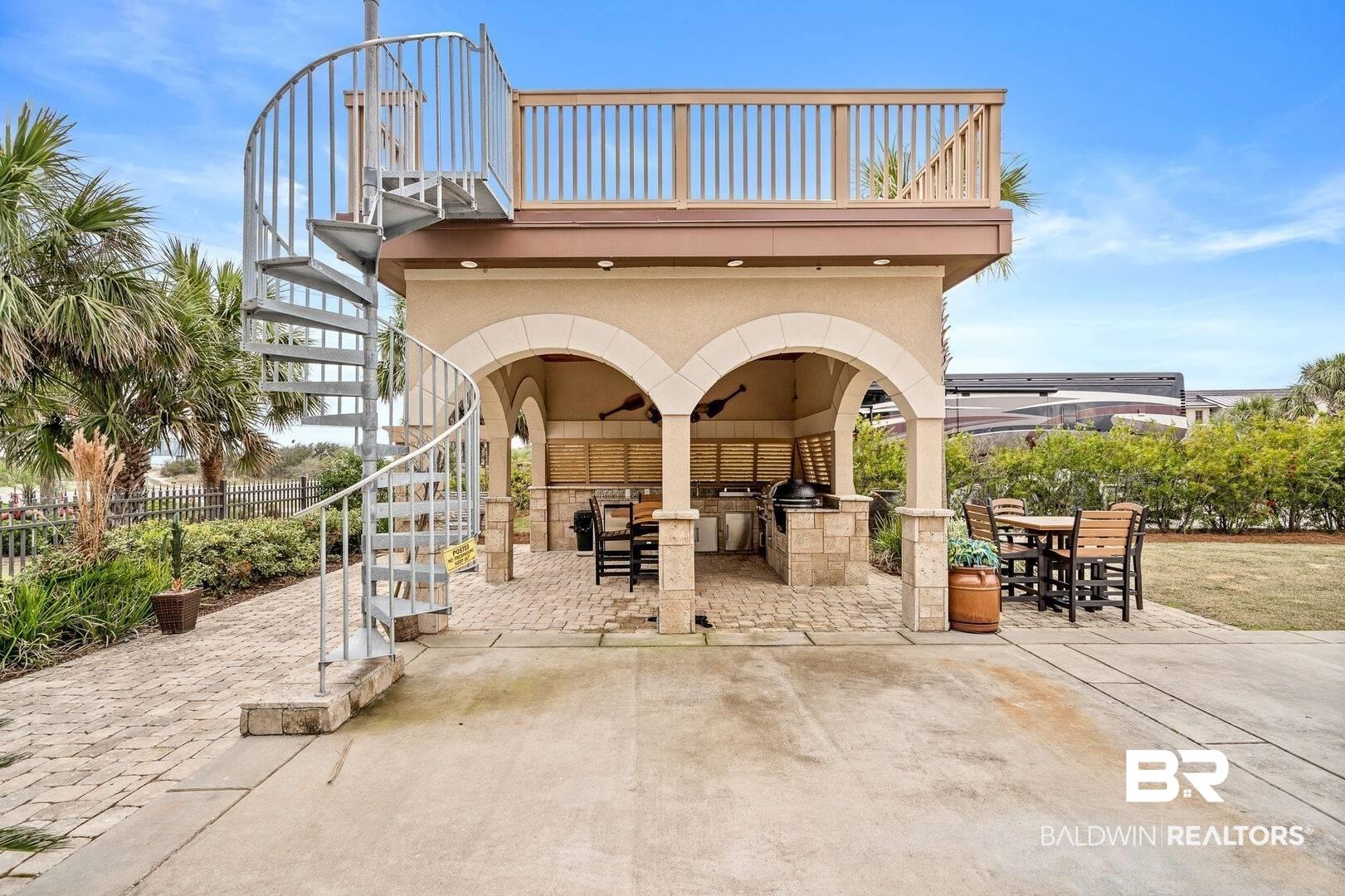 Image 3: View of patio with stairway, outdoor dining space, and an outdoor kitchen