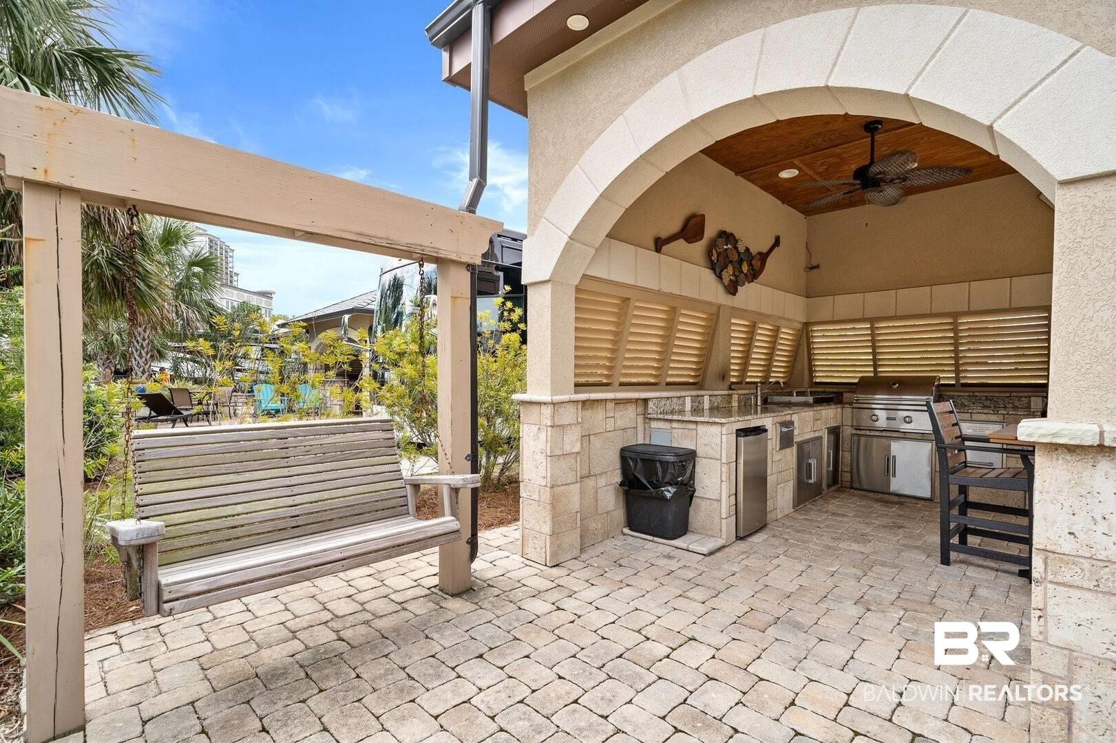 Image 4: View of patio / terrace with exterior kitchen, ceiling fan, a bar, and a pergola