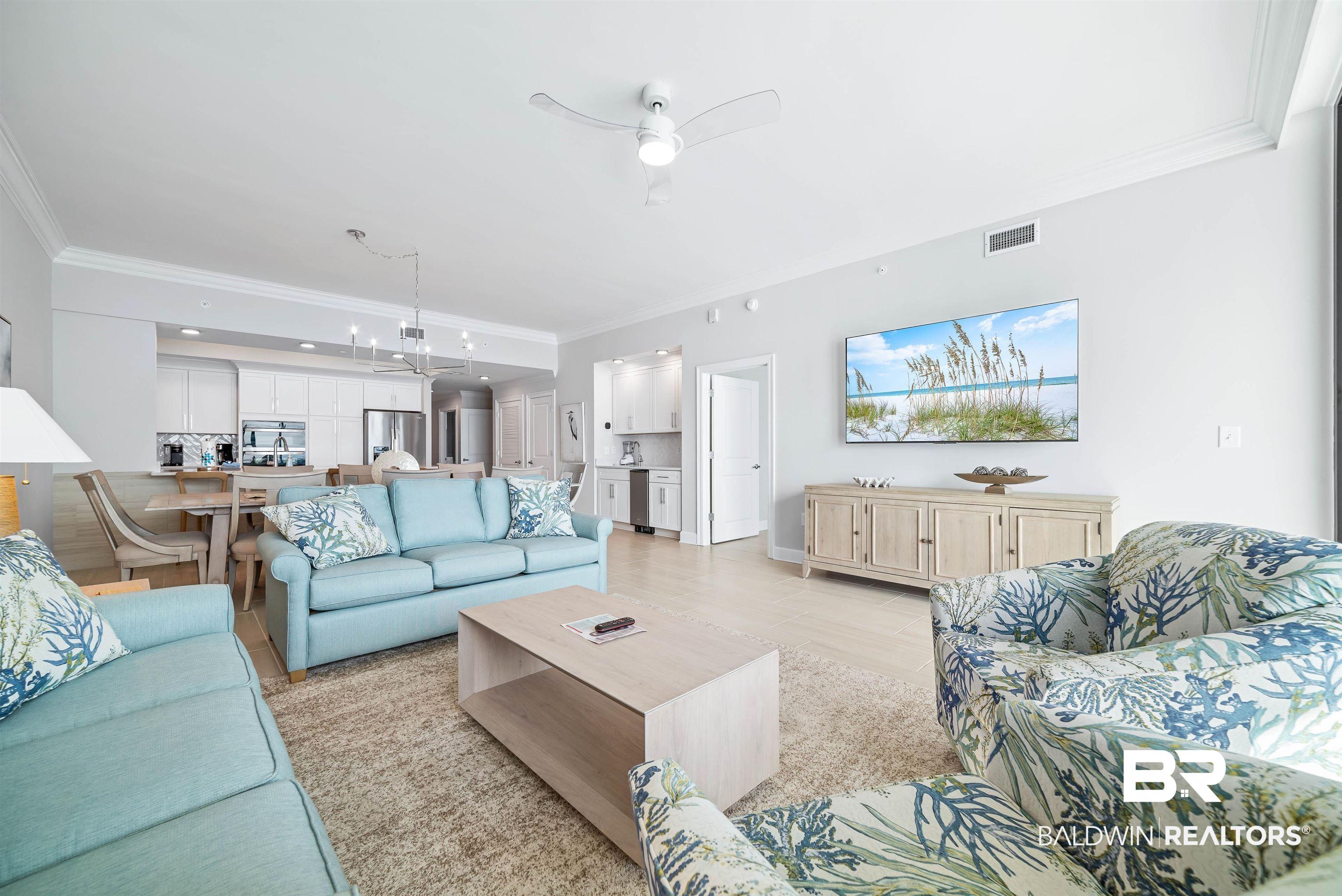 Image 4: Living area featuring crown molding, a ceiling fan, and a chandelier