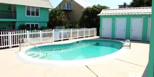 Image 4: View of pool with patio surround and an outbuilding