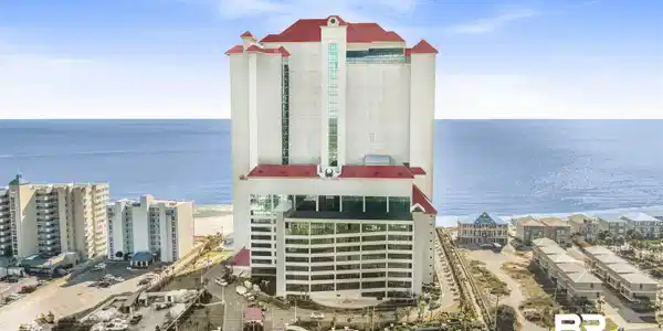 Image 2: High-rise building featuring a red roofline and white facade