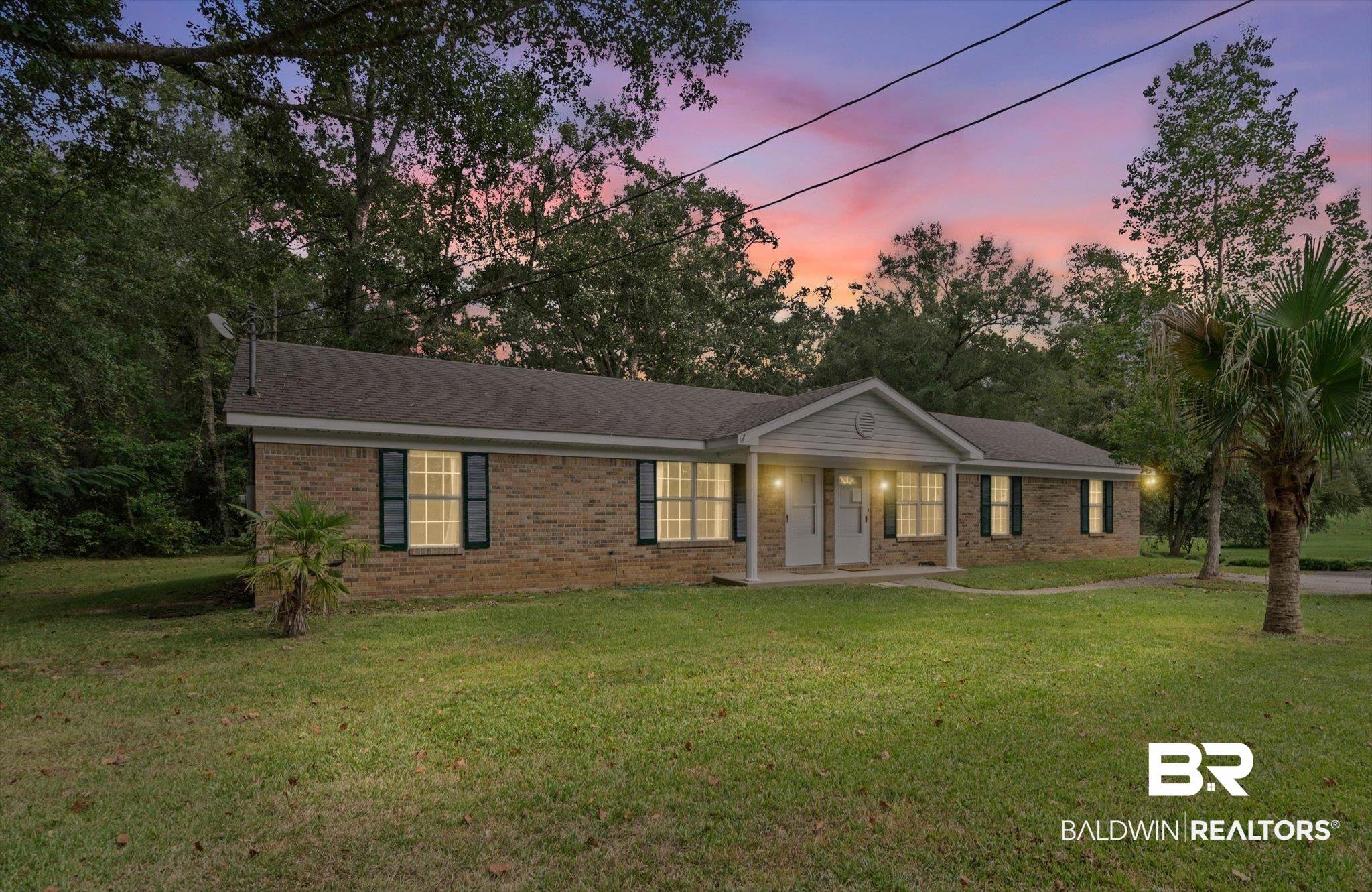 Image 1: Ranch-style home featuring a yard, covered porch, brick siding, and a shingled roof