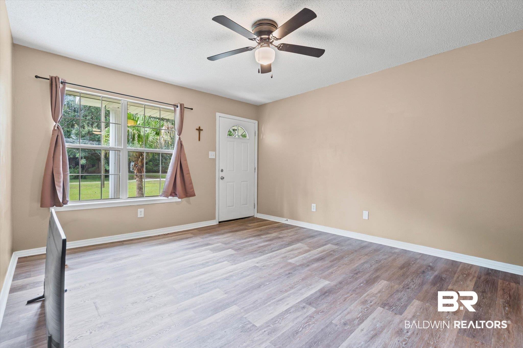 Image 3: Entrance foyer featuring light wood-style flooring, a textured ceiling, and a ceiling fan