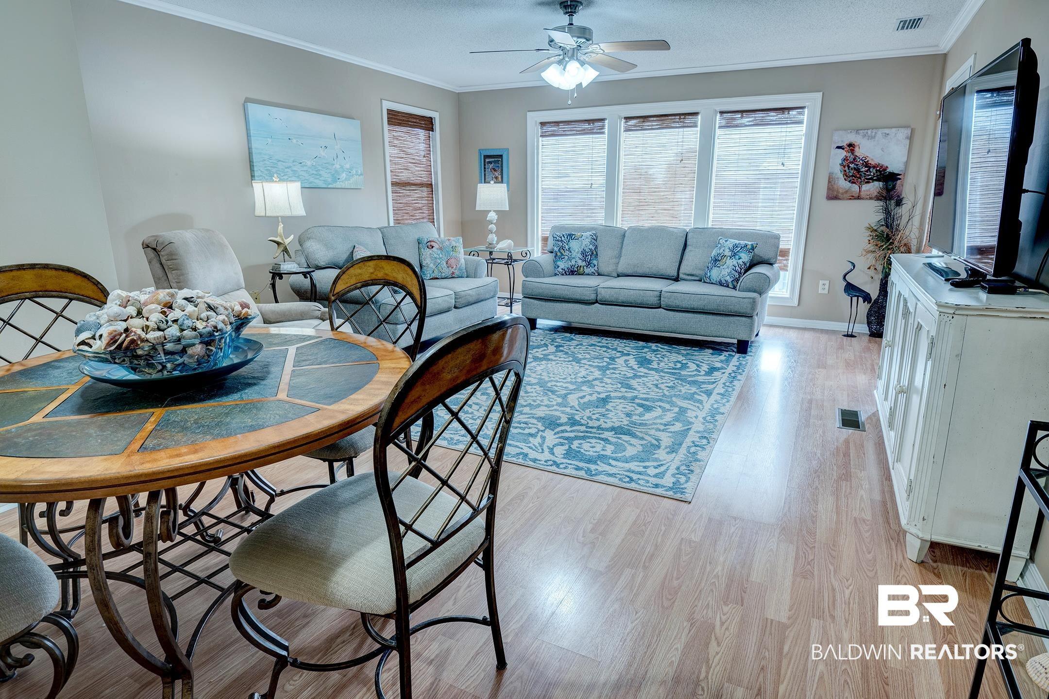 Image 2: Living area with ornamental molding, light wood-style flooring, a ceiling fan, and a textured ceiling