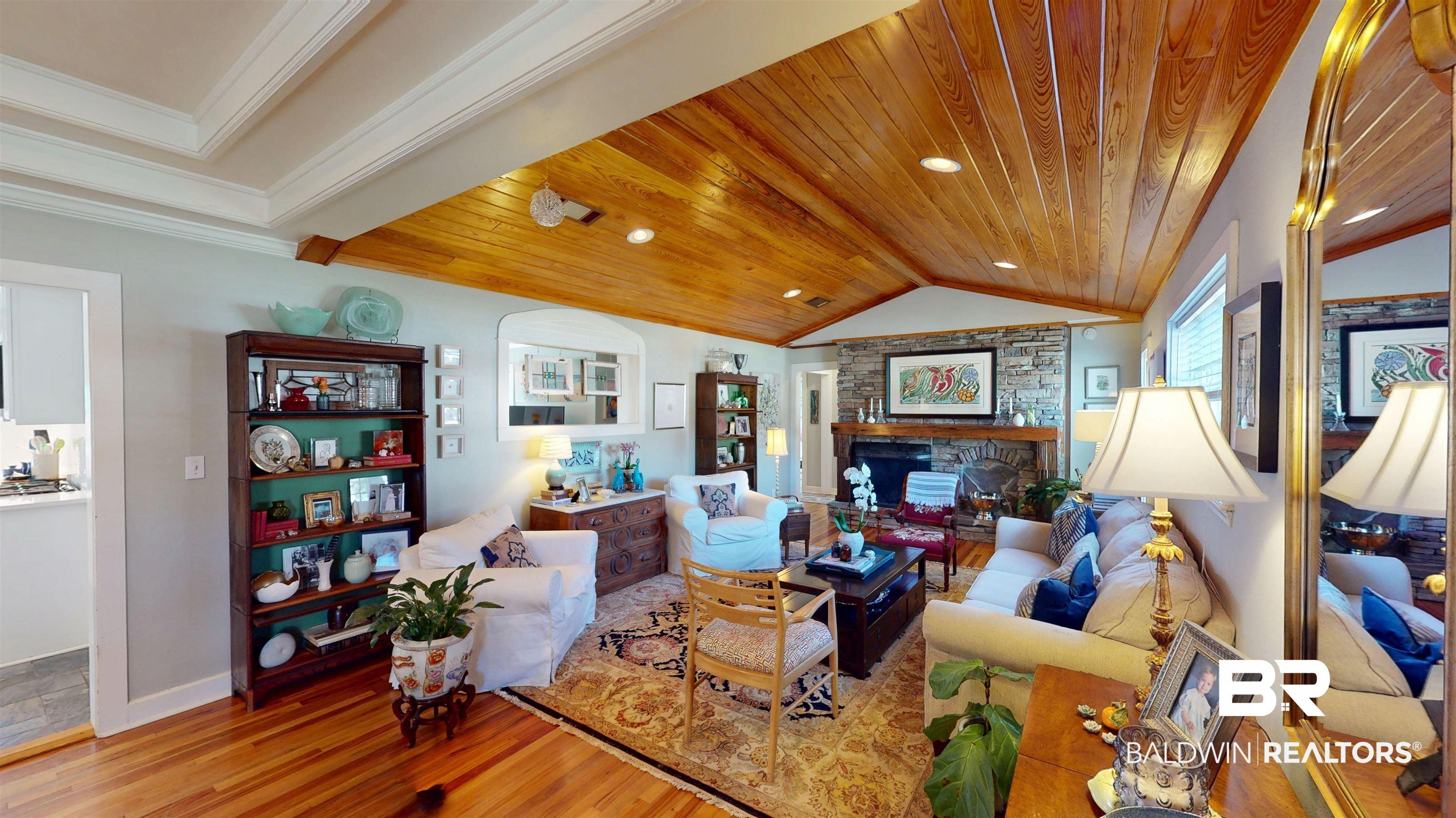 Image 4: Living area featuring a fireplace, light wood finished floors, wooden ceiling, and recessed lighting