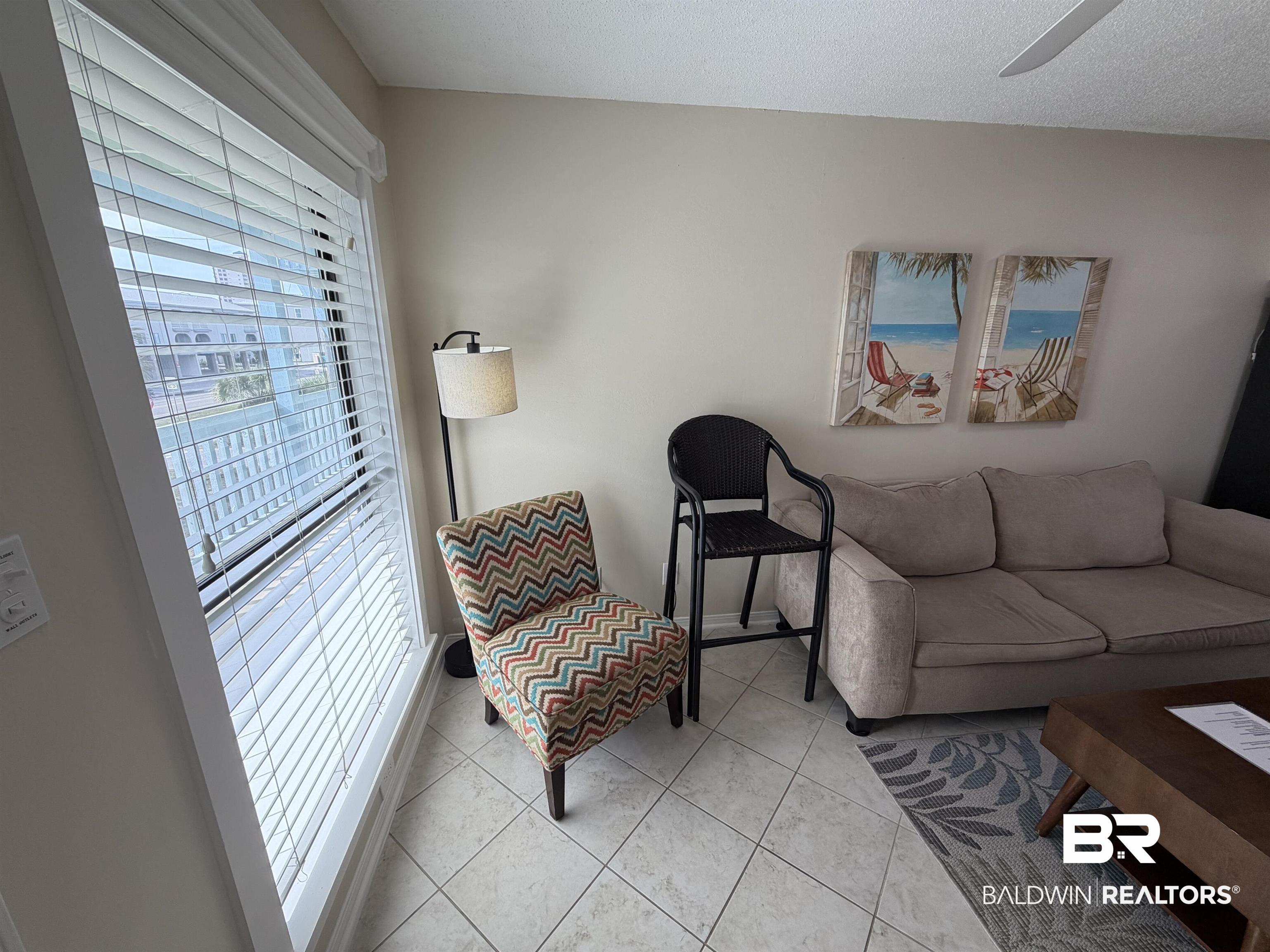 Image 4: Living area featuring light tile patterned flooring and a ceiling fan