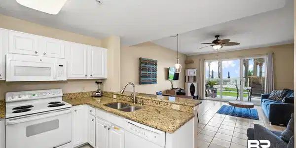 Image 2: Kitchen featuring white appliances, light tile patterned floors, a peninsula, a sink, and open floor plan