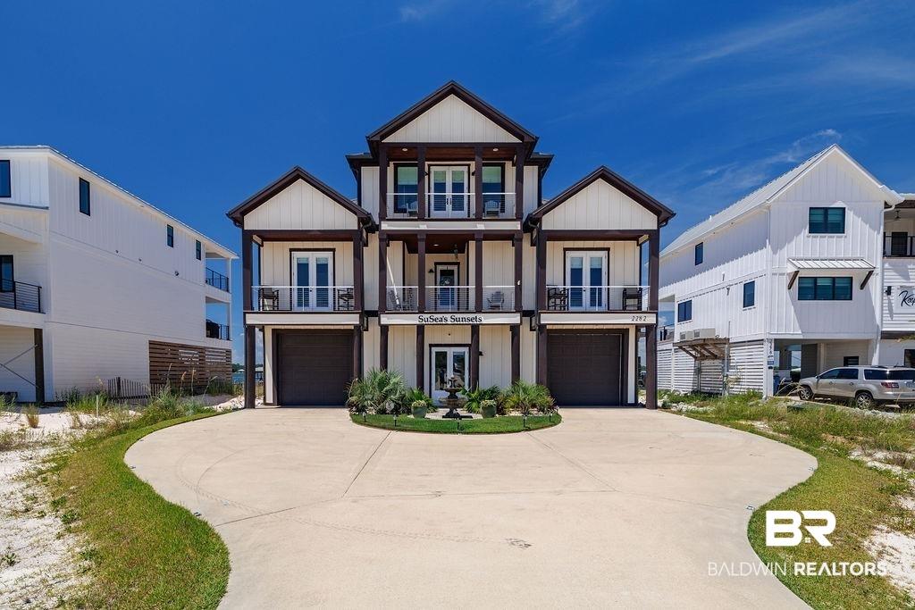 Image 2: View of front of property with french doors, a balcony, and an attached garage