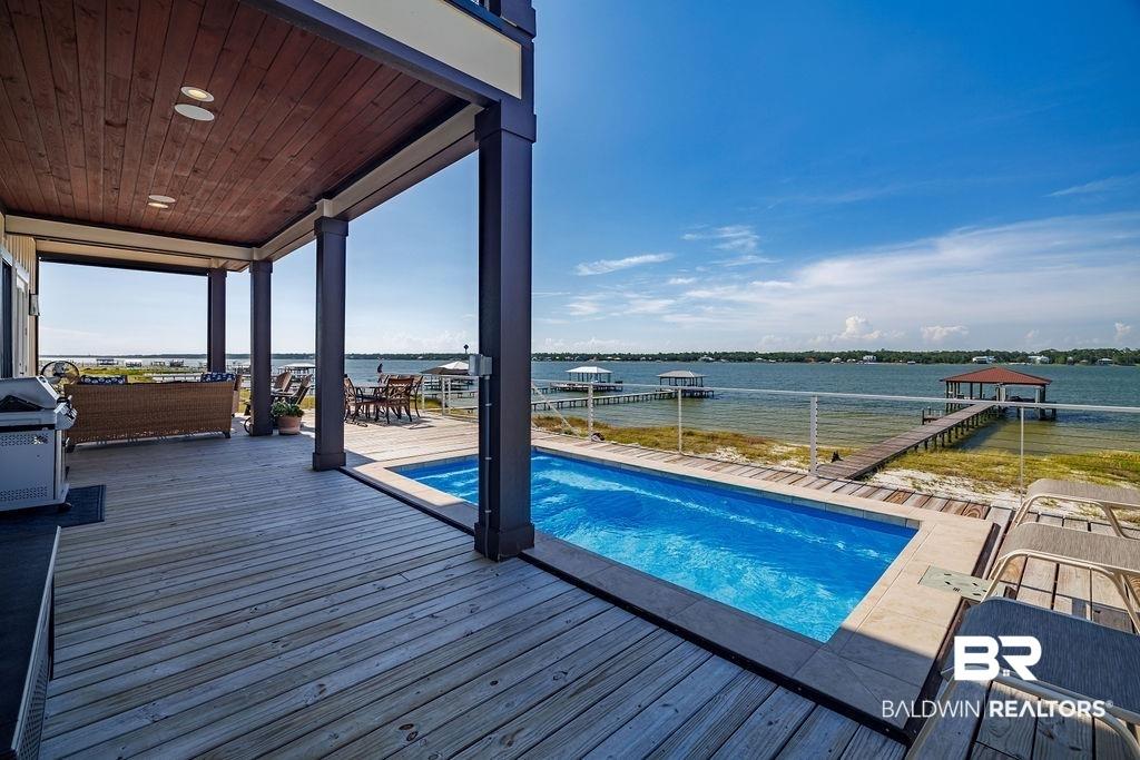 Image 4: Swimming pool featuring a water view and a grill