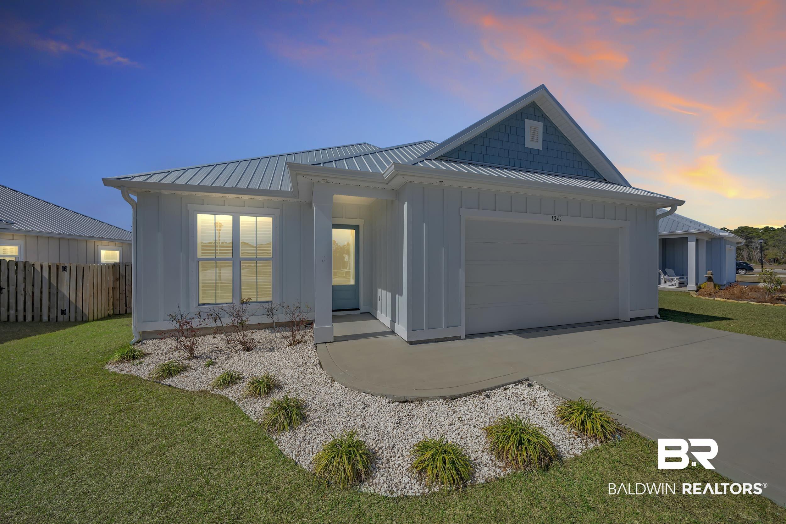 Image 1: Single-story residence featuring a metal roof, white vertical siding, and a light blue accent gable