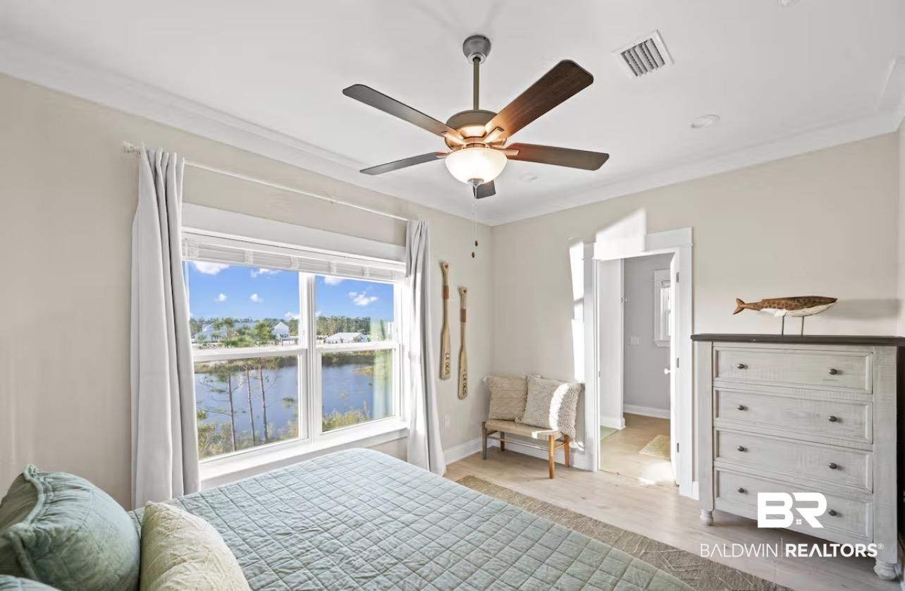 Image 4: Bedroom featuring crown molding, a water view, light wood finished floors, and a ceiling fan