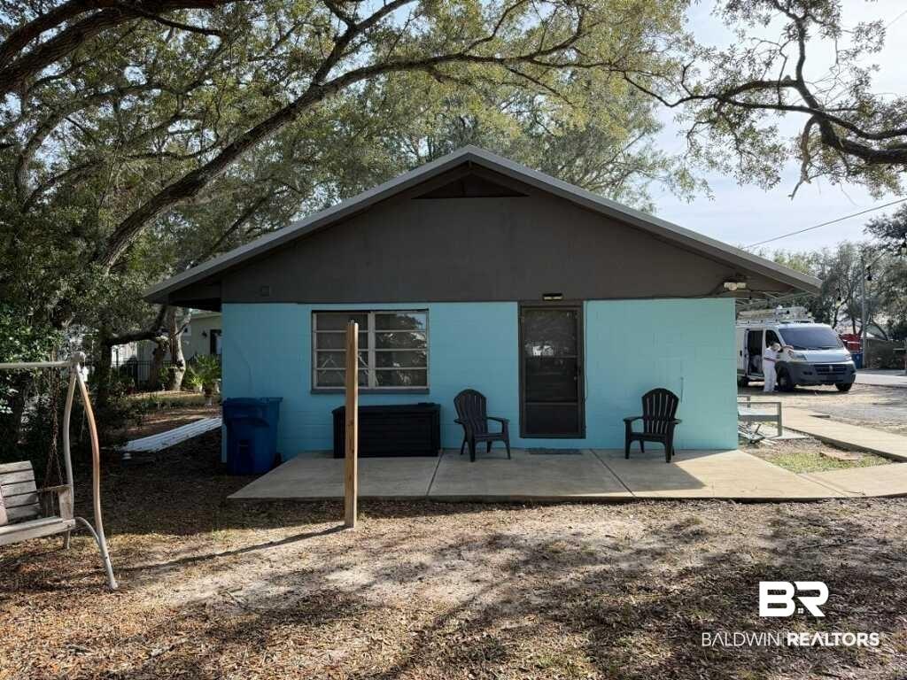 Image 2: Single-story residence featuring a light blue facade and a dark brown trim