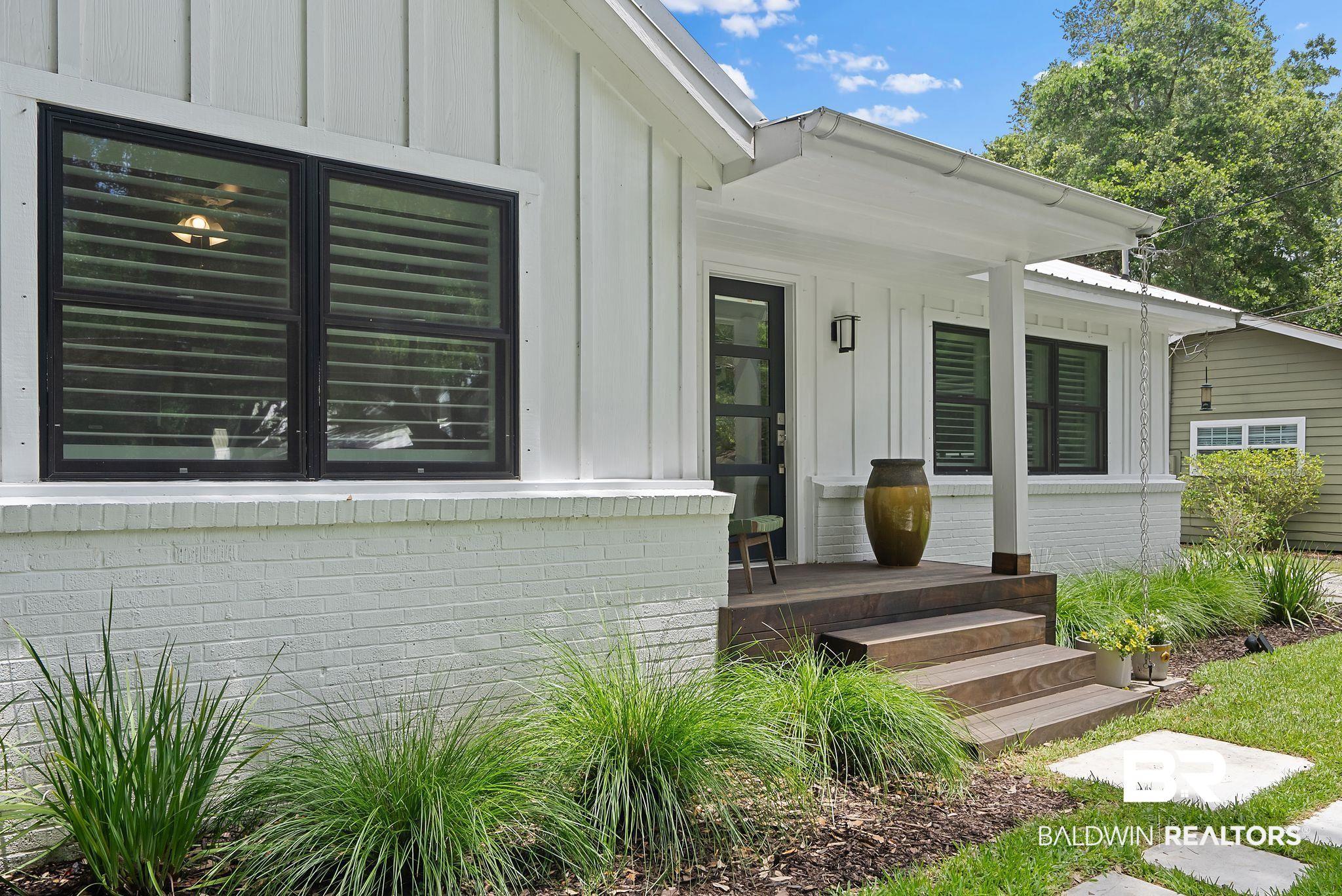 Image 4: Inviting covered front porch with stained wood steps and decking