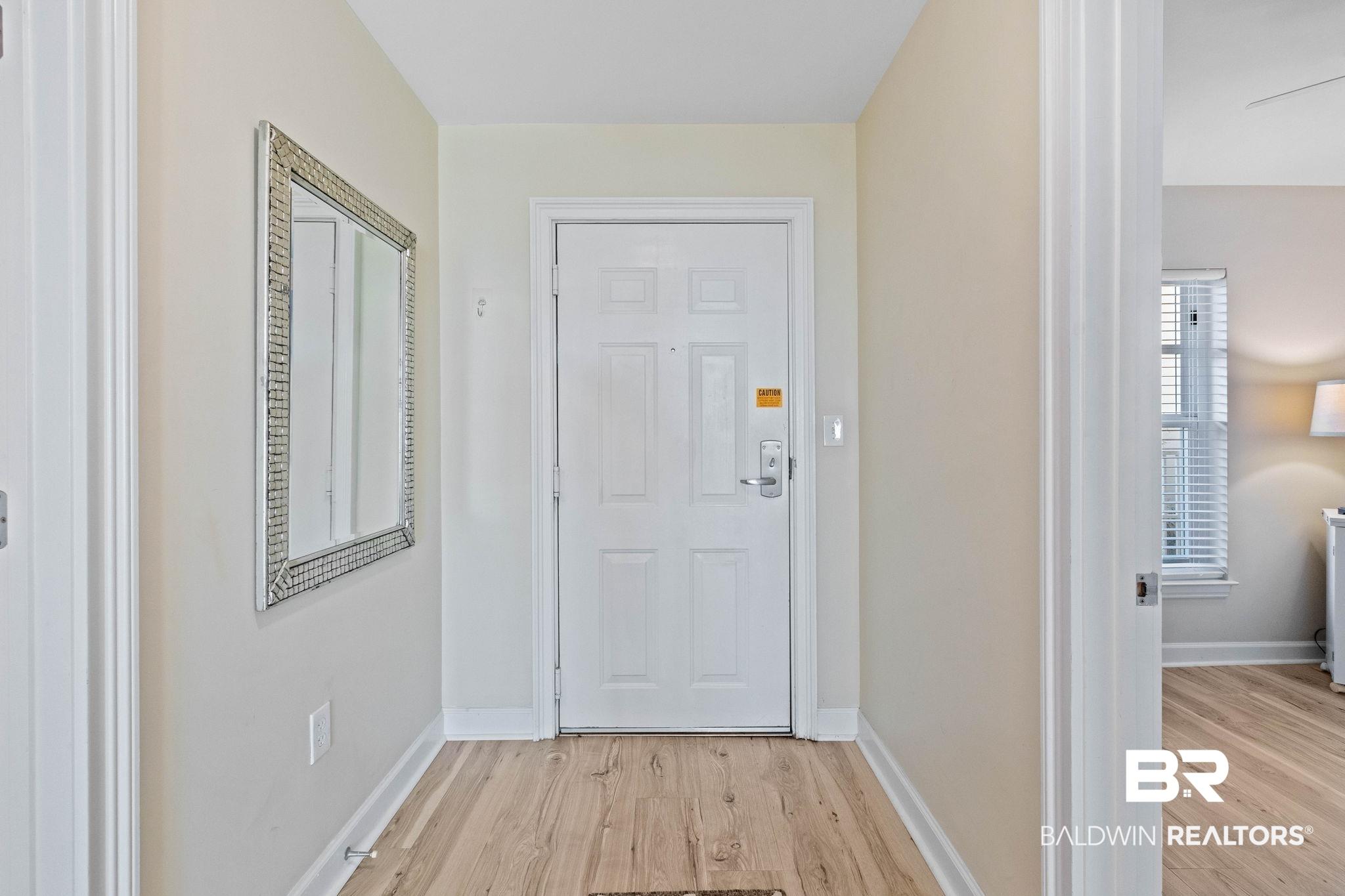 Image 3: Doorway featuring wood finished floors and baseboards