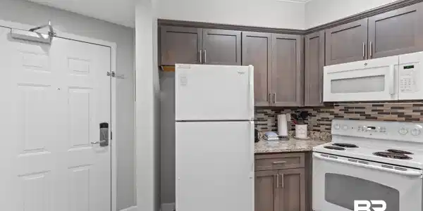 Image 4: Kitchen featuring white appliances, dark brown cabinets, light tile patterned flooring, a textured ceiling, and crown molding
