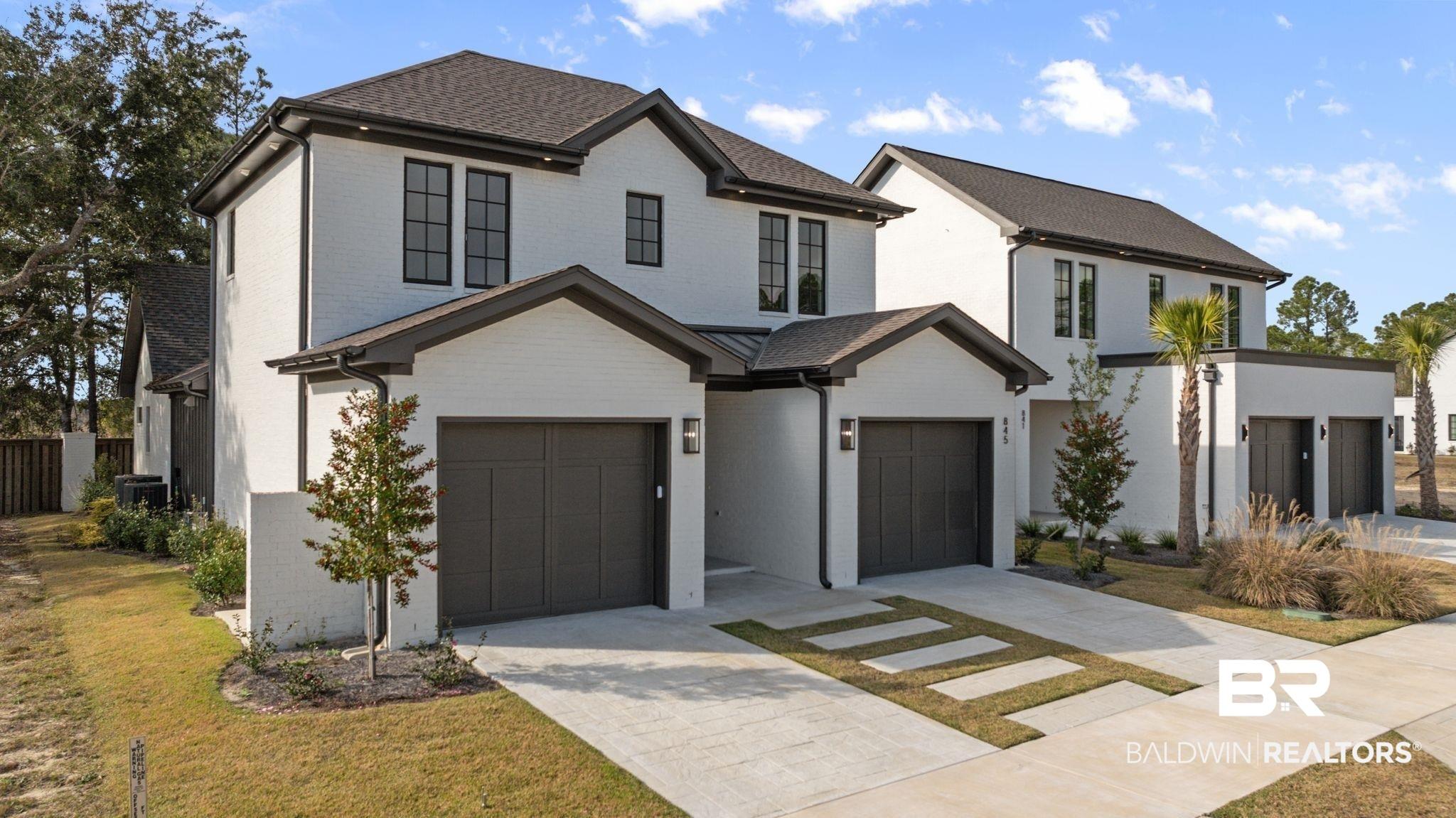 Image 3: View of front of house featuring brick siding, concrete driveway, a front yard, and an attached garage