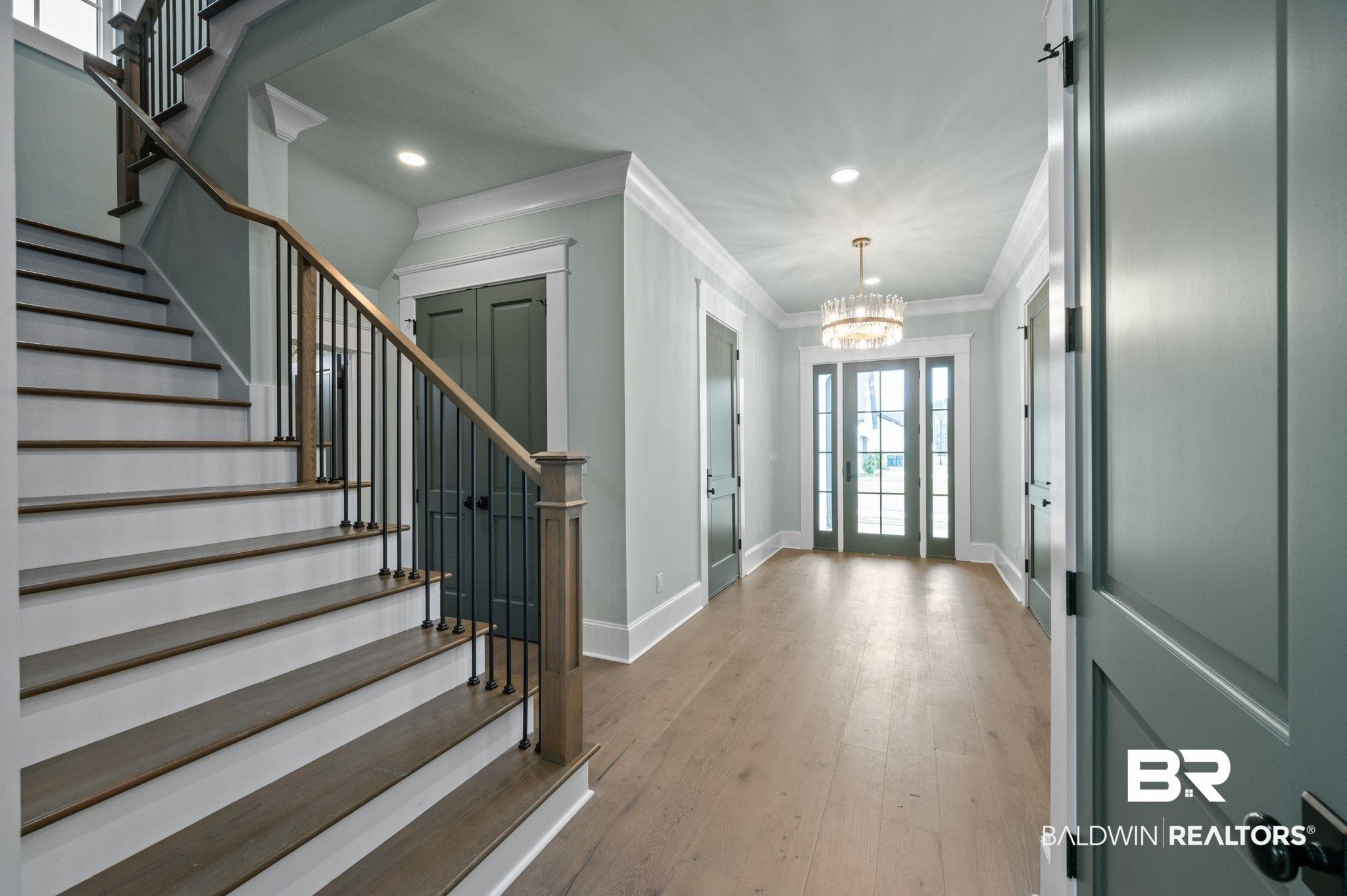 Image 4: Entryway with ornamental molding, stairway, light wood-style floors, a chandelier, and recessed lighting