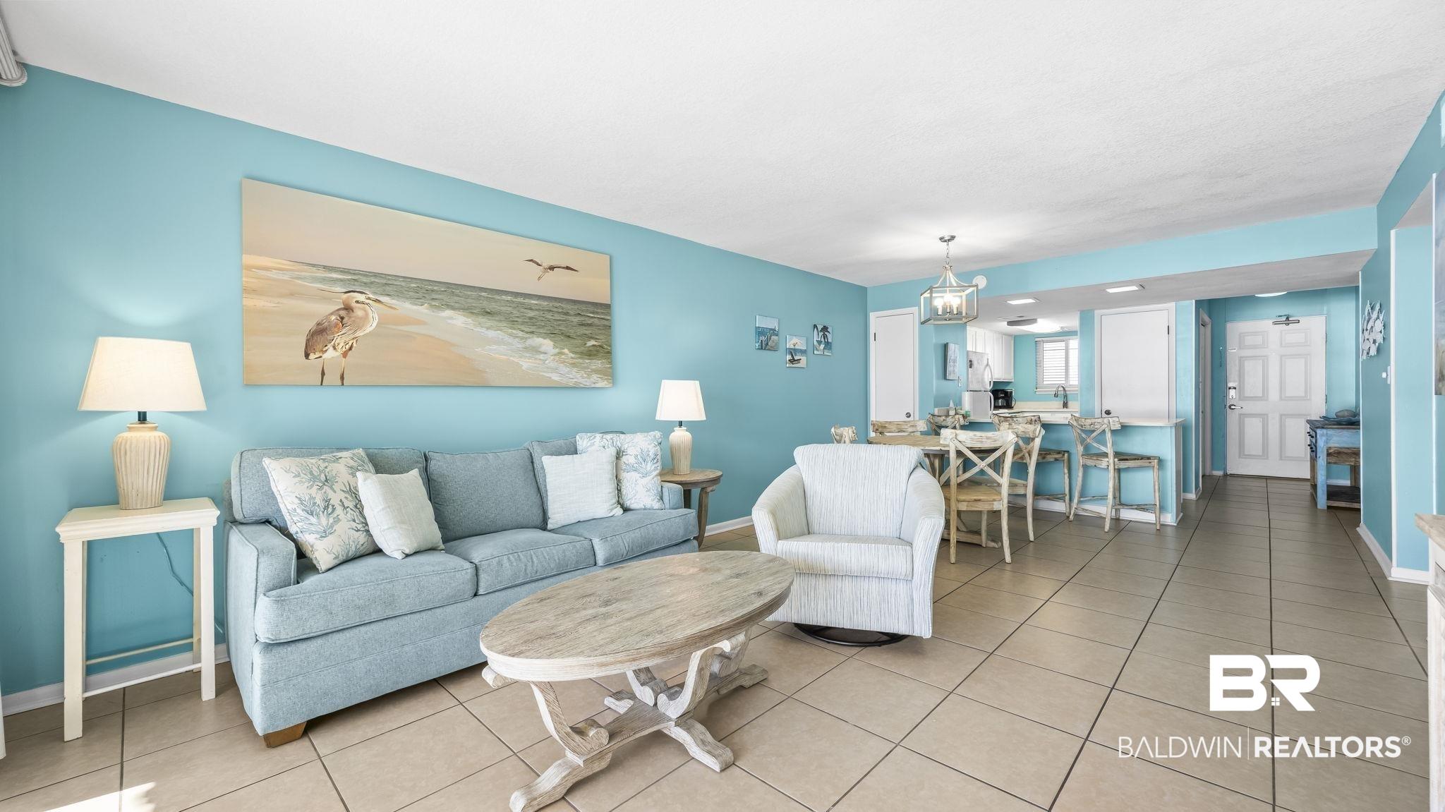 Image 2: Living room featuring tile patterned floors and baseboards