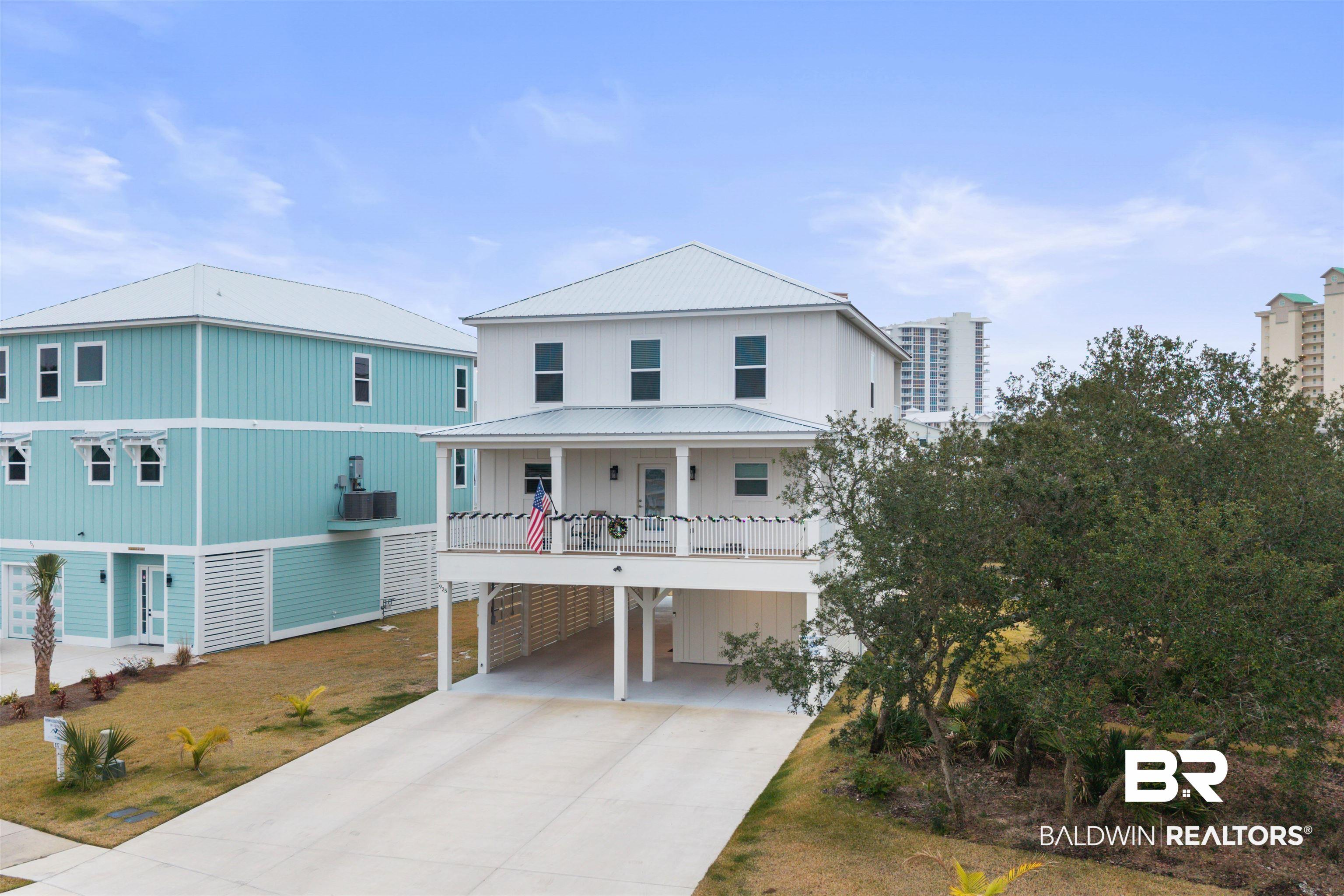 Image 3: Raised beach house featuring a carport and concrete driveway