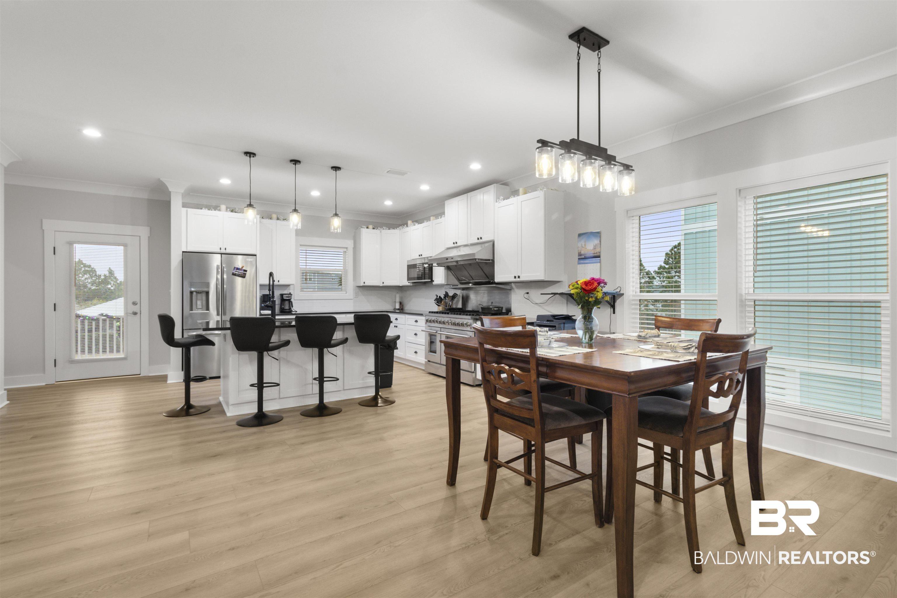 Image 4: Dining area with crown molding, light wood-style floors, recessed lighting, and healthy amount of natural light