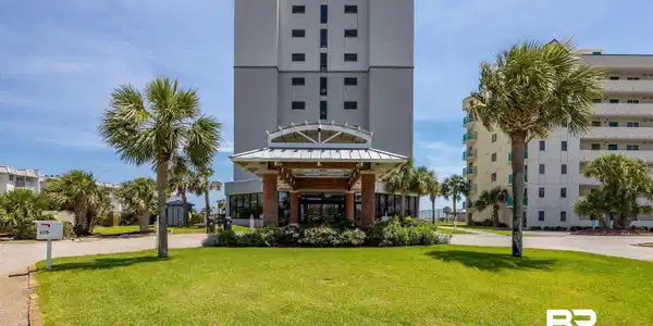 Image 2: High-rise building featuring a covered entrance, contemporary architectural style, and surrounding palm trees