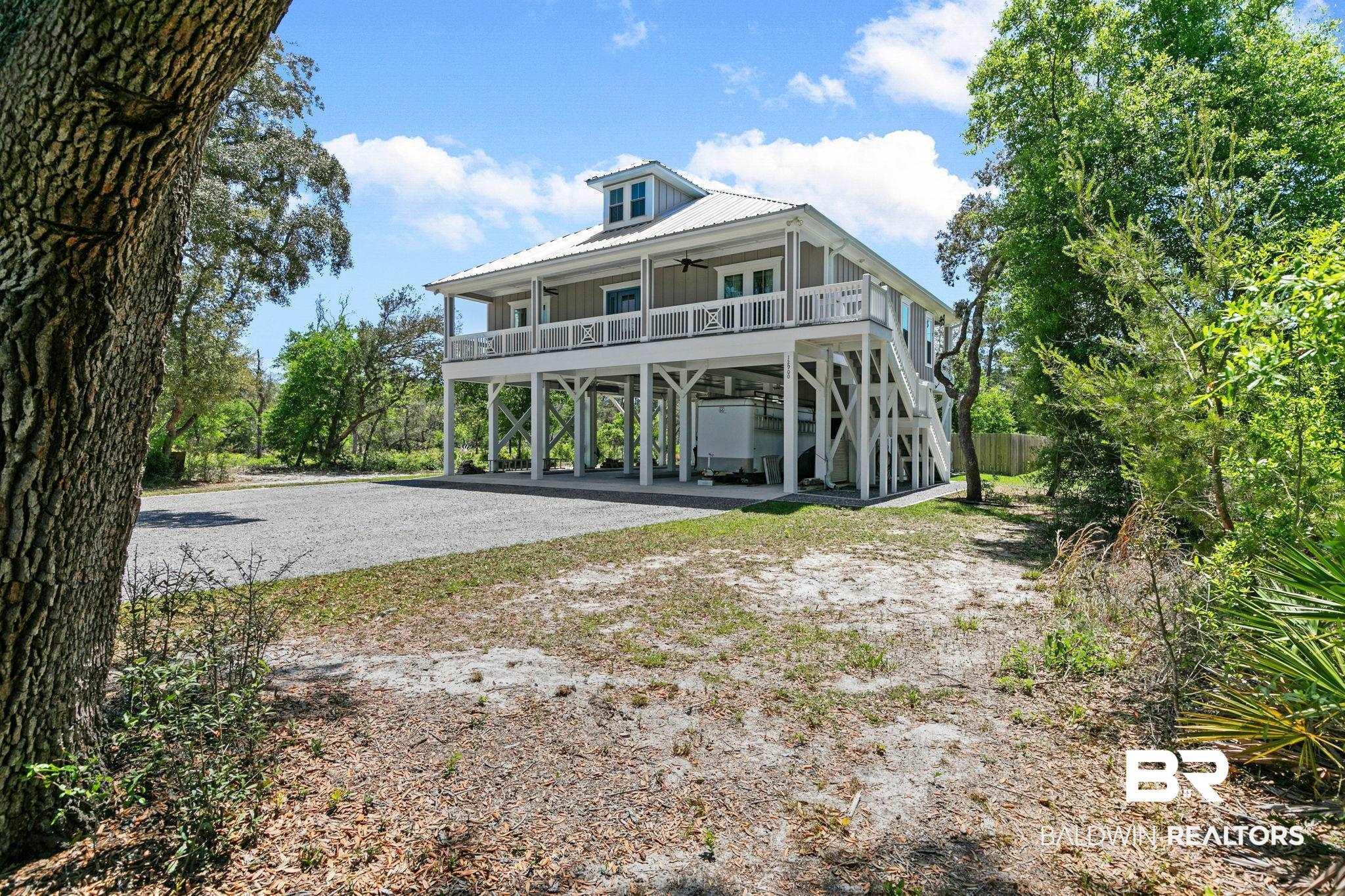 Image 4: Back of property with a carport, ceiling fan, driveway, covered porch, and a metal roof