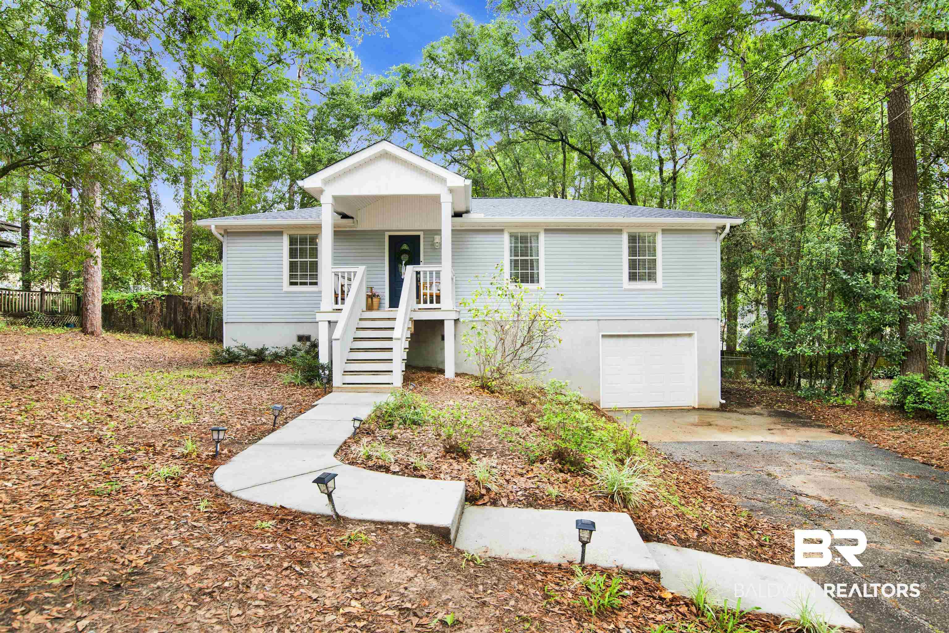 Image 1: Light blue siding exterior with a covered porch and white railings