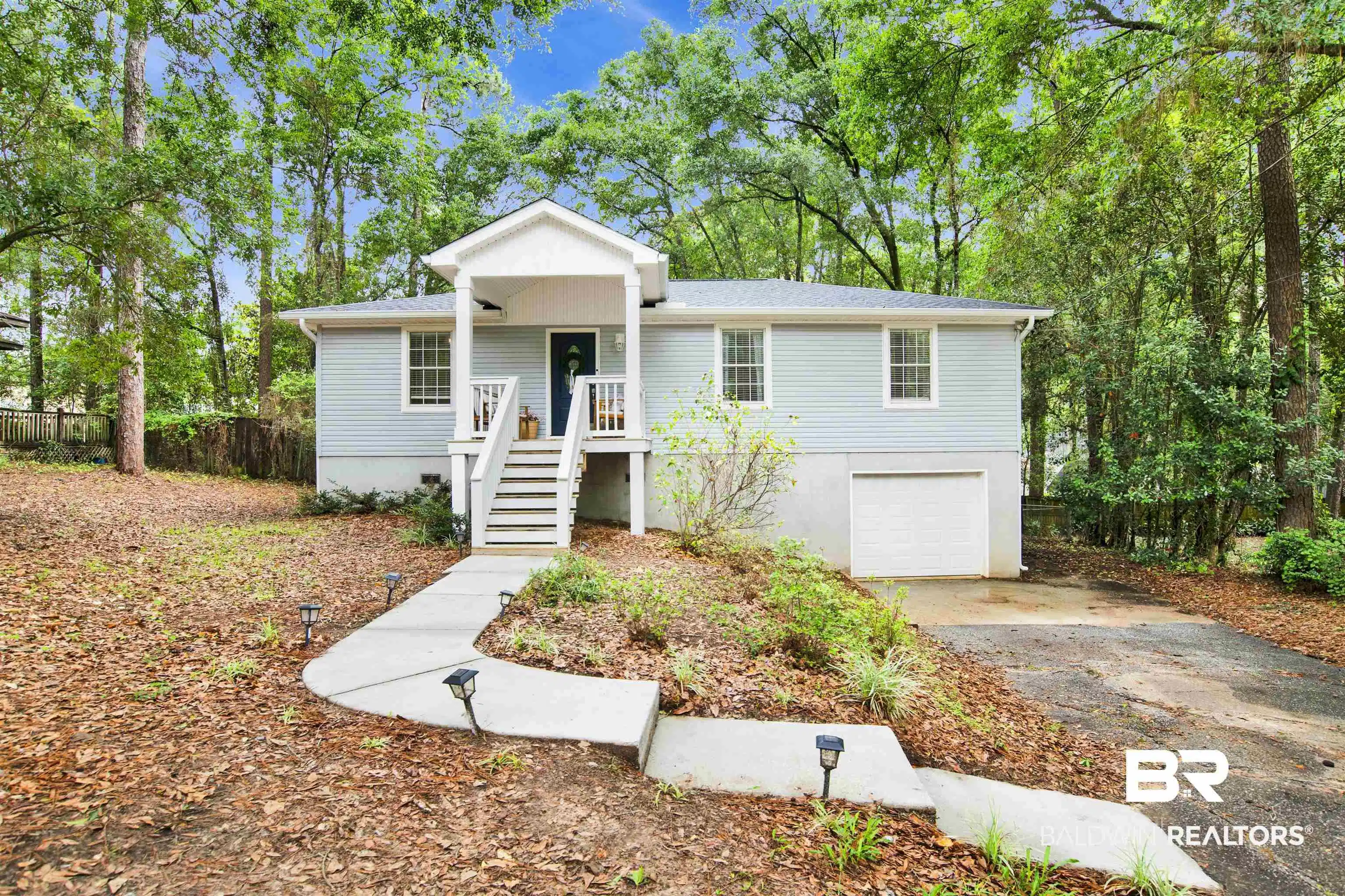 Image 1: Light blue siding exterior with a covered porch and white railings