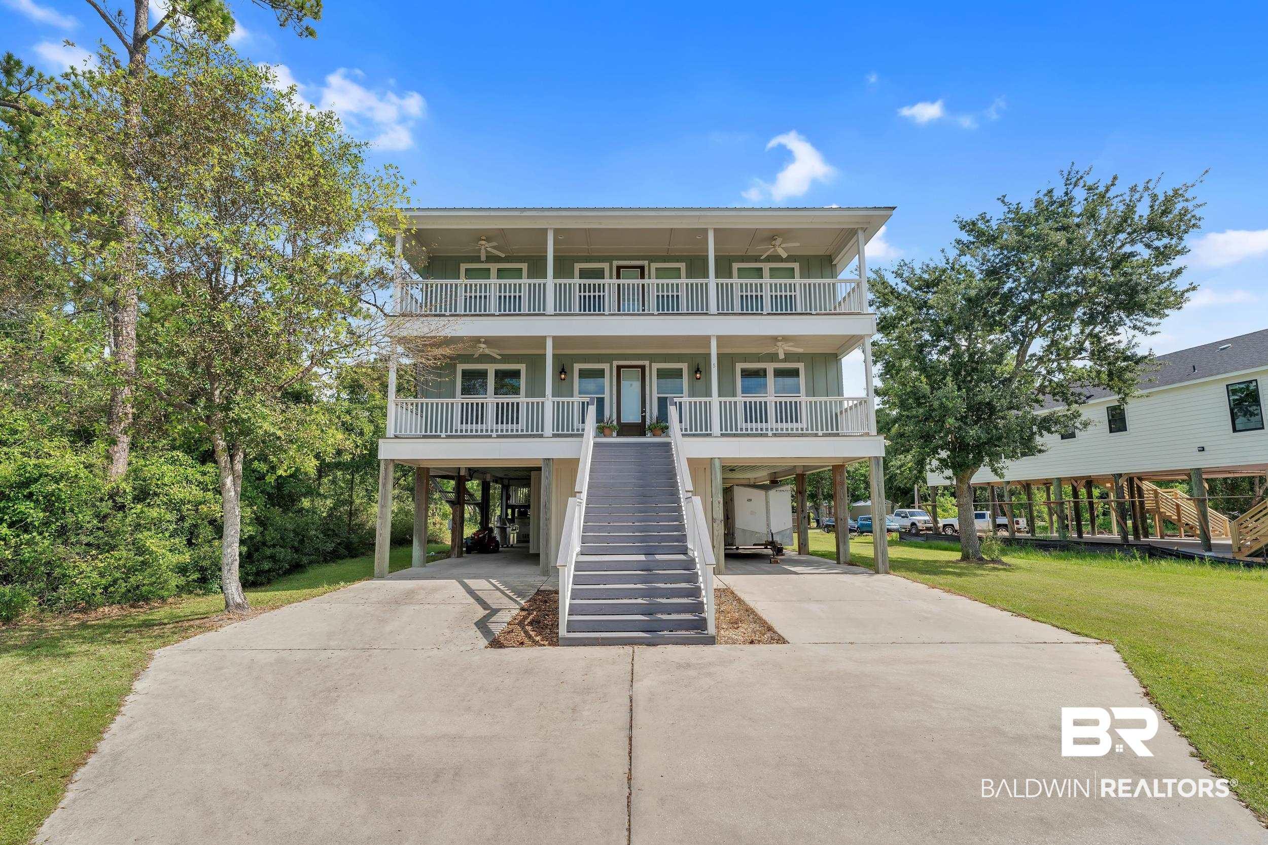 Image 2: View of front of property featuring a carport, ceiling fan, covered porch, driveway, and stairs