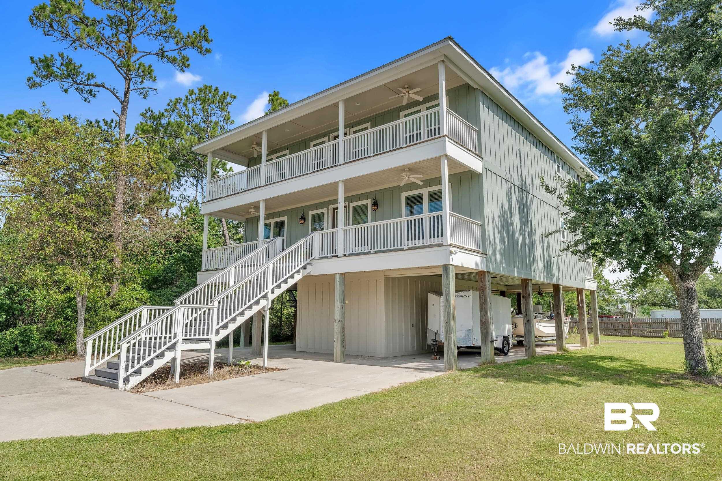 Image 3: View of front of house featuring a ceiling fan, a balcony, a carport, and stairway