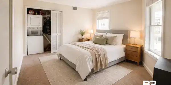 Image 4: Bedroom with stacked washing machine and dryer, a closet, carpet, and crown molding