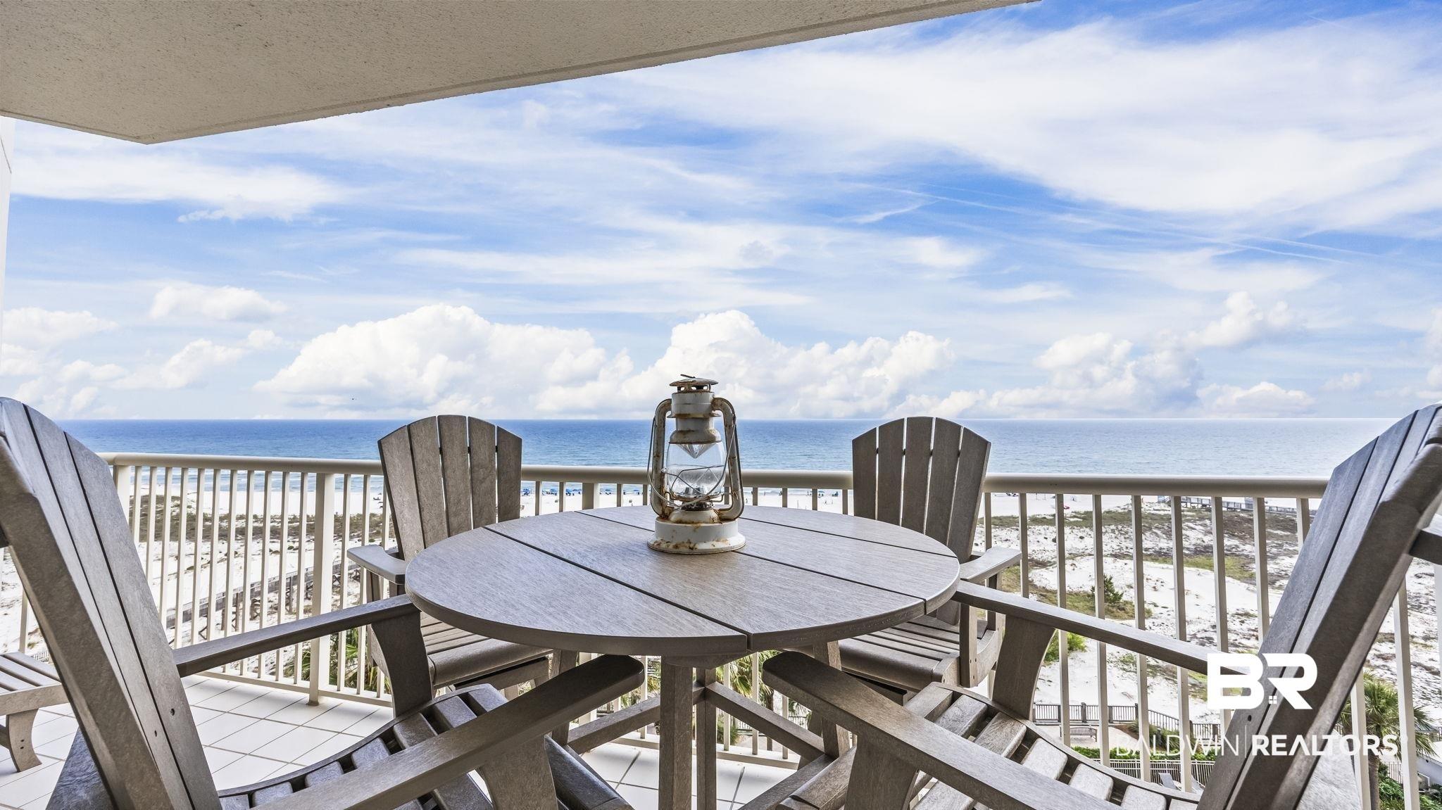 Image 2: Balcony featuring white tile flooring, a white metal railing, and an expansive ocean backdrop