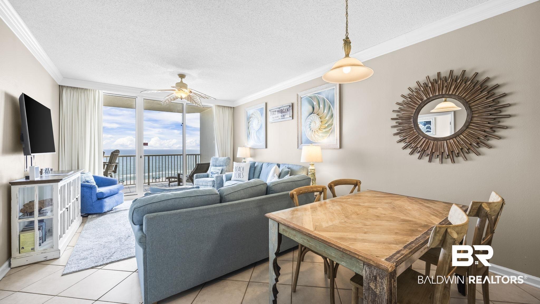 Image 4: Open-concept living area with a balcony featuring metal railings and ocean scenery