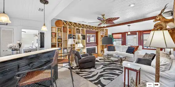 Image 4: Living area featuring a fireplace, ceiling fan, wood ceiling, and carpet flooring