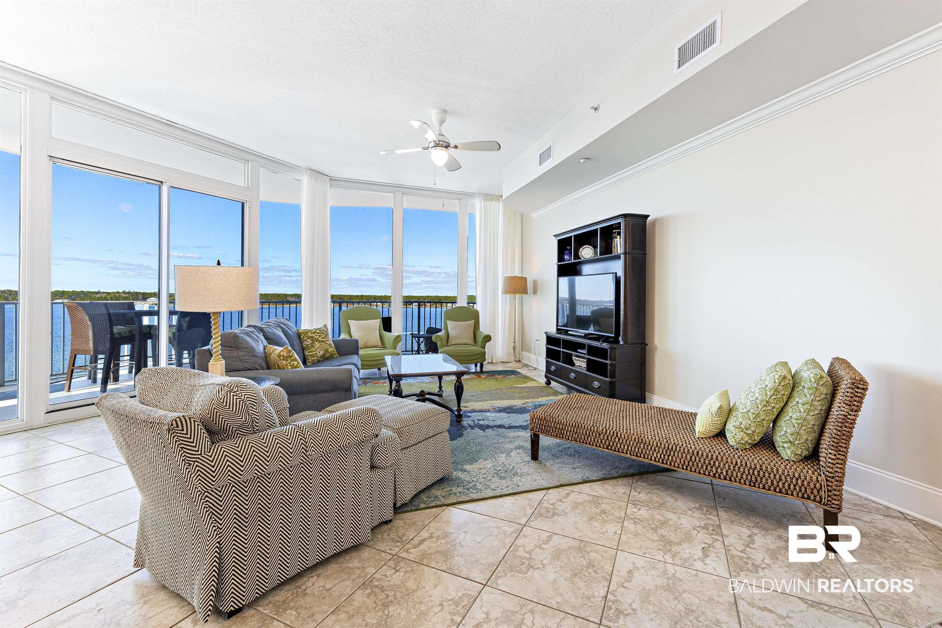 Image 3: Living area with floor to ceiling windows, ceiling fan, light tile patterned floors, and ornamental molding