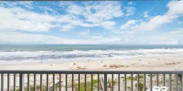 Image 2: Expansive oceanfront balcony featuring a white railing and a textured ceiling