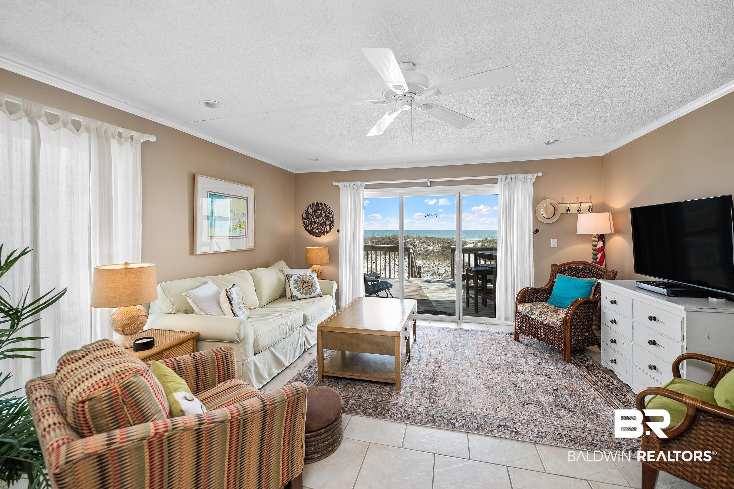 Image 3: Living area featuring crown molding, light tile patterned floors, a textured ceiling, and ceiling fan
