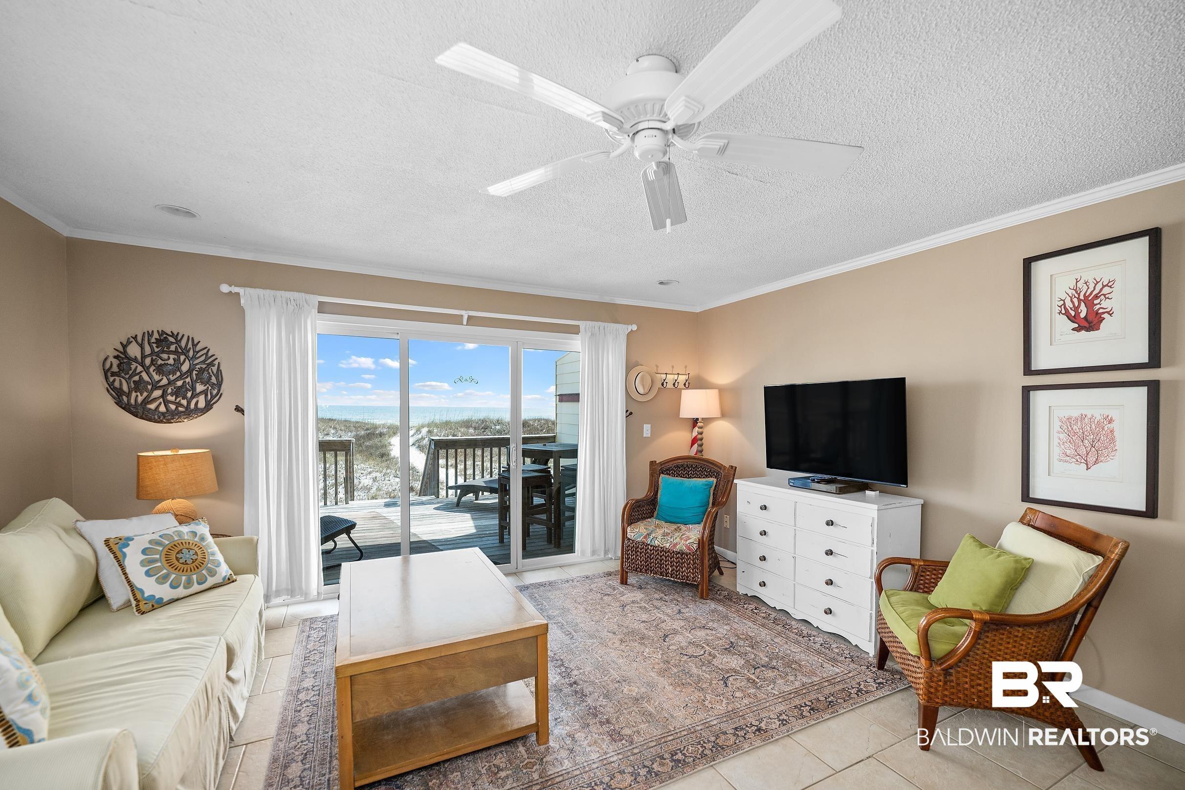 Image 4: Living area with a ceiling fan, ornamental molding, a textured ceiling, and light tile patterned floors