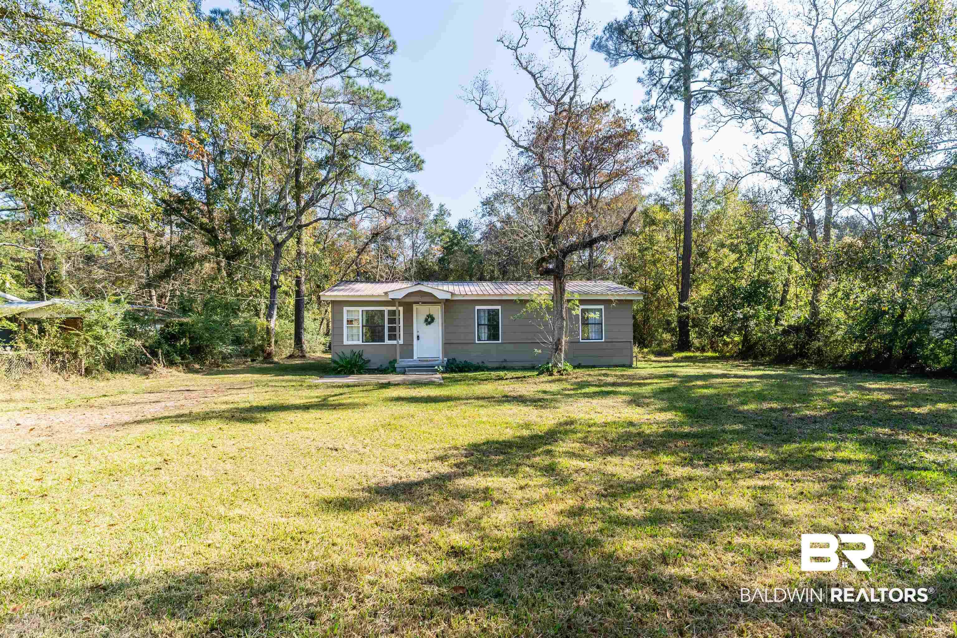 Image 1: Ranch-style home featuring a front lawn and a metal roof