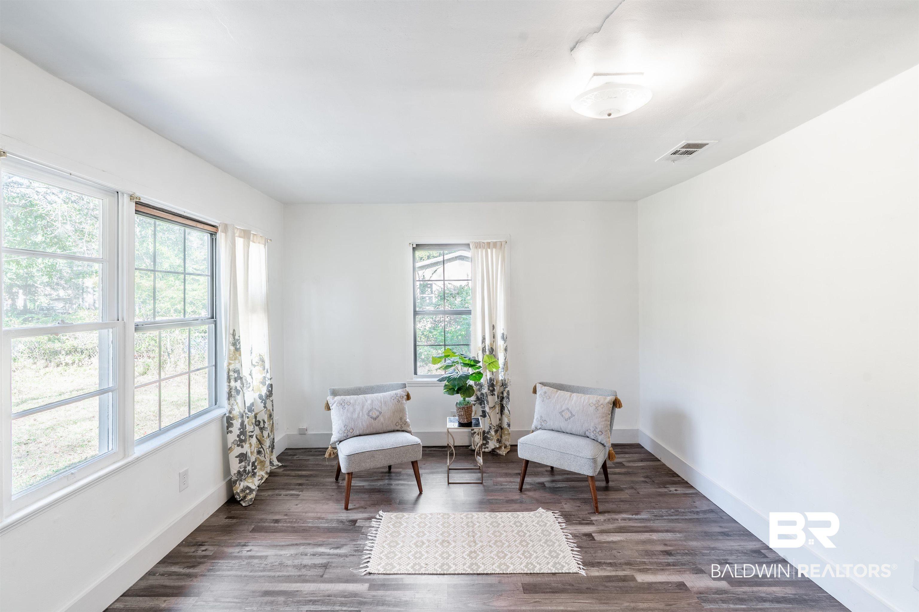 Image 4: Living area with dark wood-style floors and baseboards