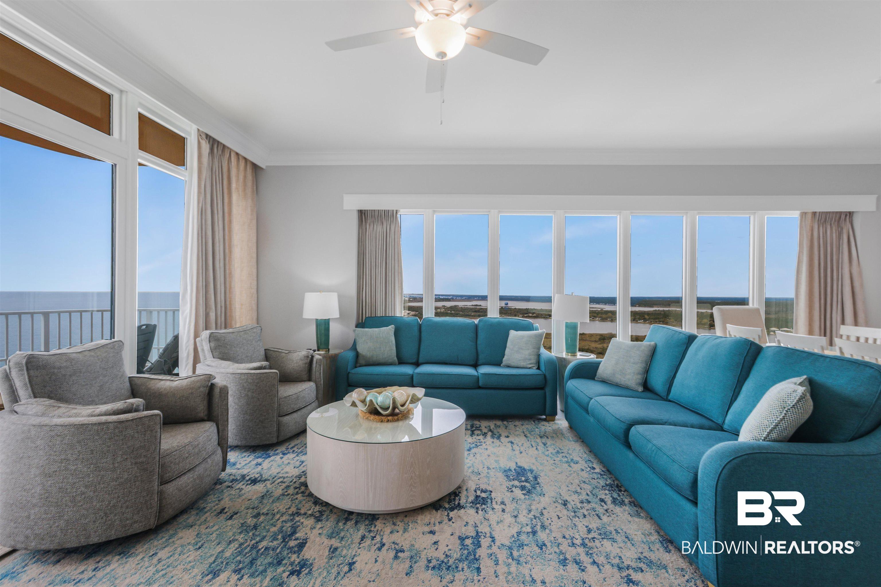 Image 4: Living room with ceiling fan, a water view, and crown molding