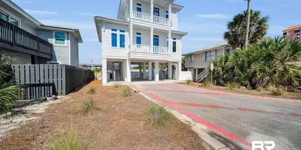 Image 2: Beach home featuring a carport, driveway, and stairway