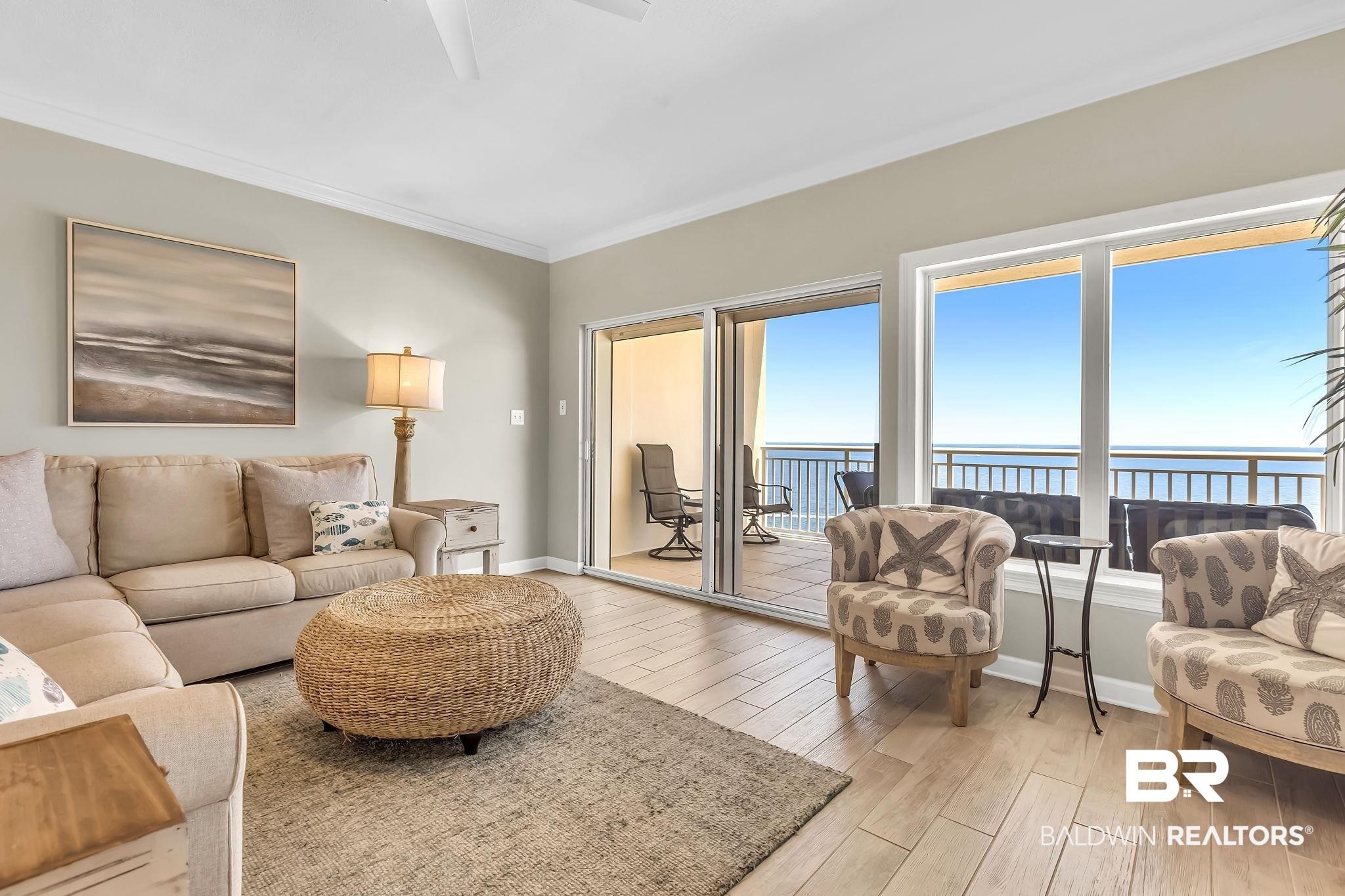 Image 4: Living room with light wood finished floors, healthy amount of natural light, a water view, and crown molding