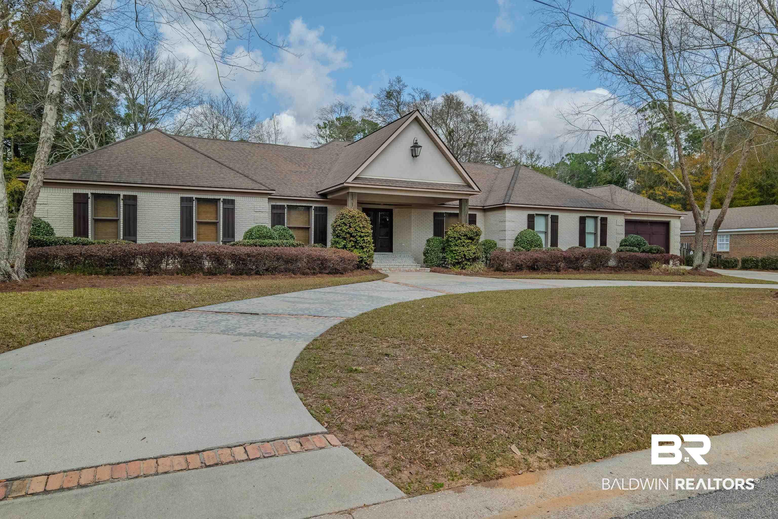 Image 1: Single story home featuring a front yard, brick siding, and curved driveway