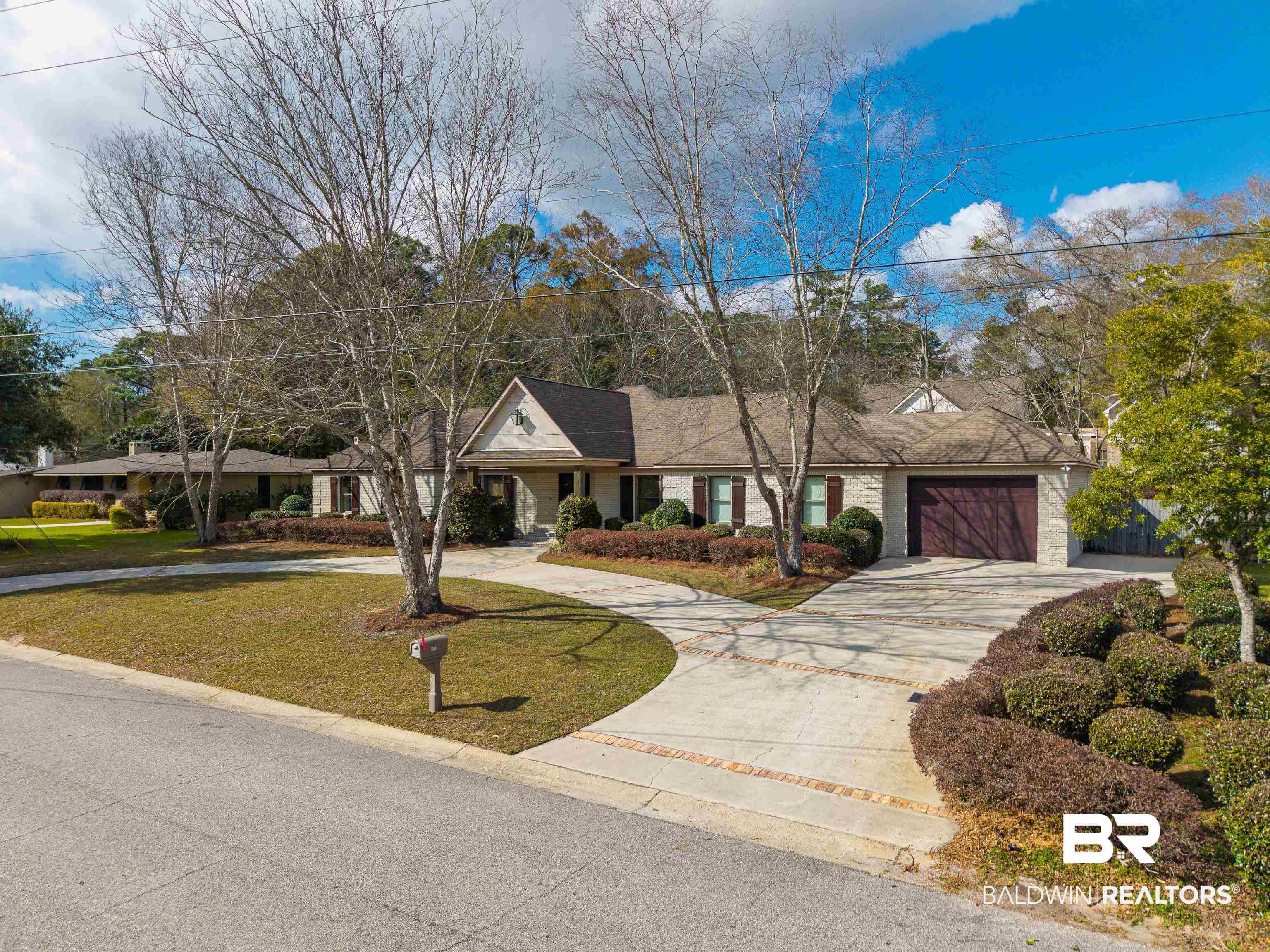 Image 2: View of front of house with curved driveway, a front lawn, and a porch