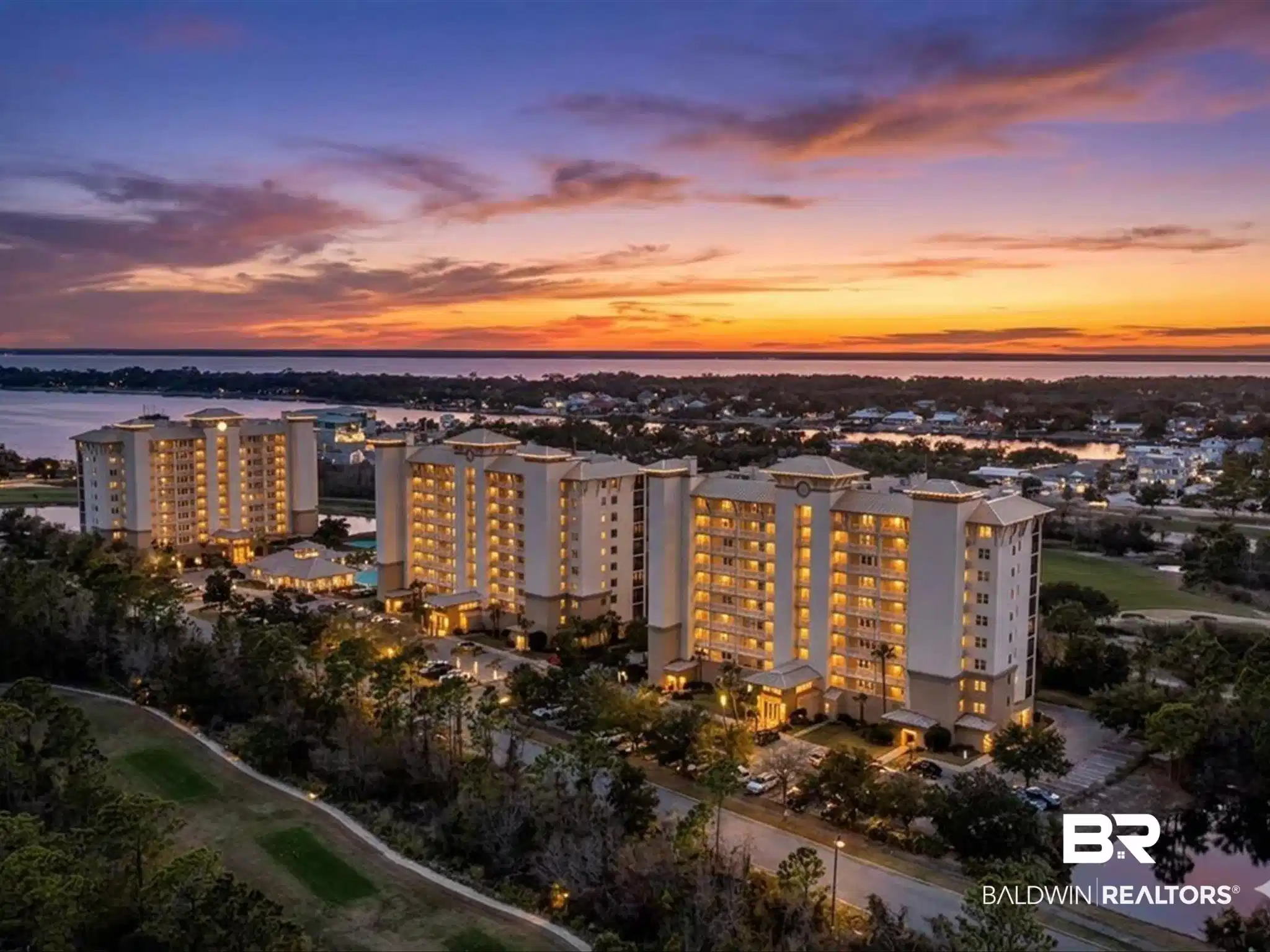 Image 1: Aerial perspective showcasing multiple residential buildings with illuminated balconies, surrounded by mature trees