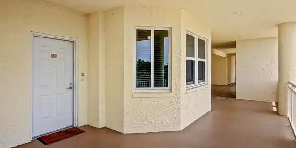 Image 2: Covered exterior walkway featuring textured stucco walls and recessed lighting